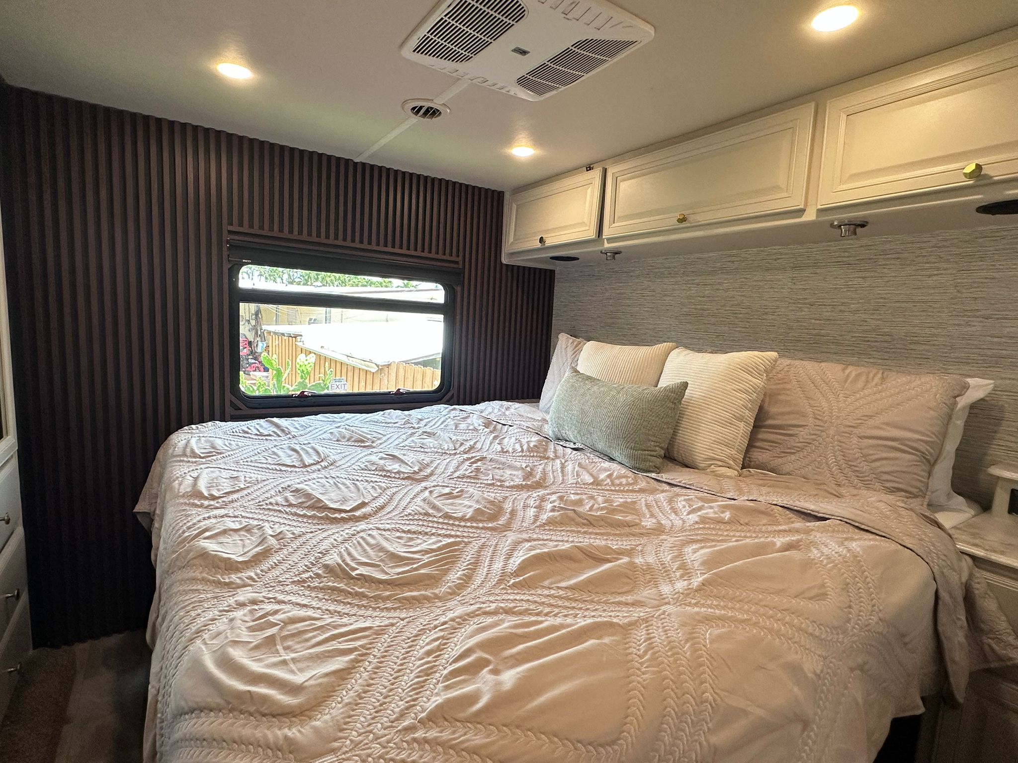 Experience comfort in this modern RV rental bedroom featuring a large bed, stylish decor, and cozy lighting.. Fleetwood Flair 2021