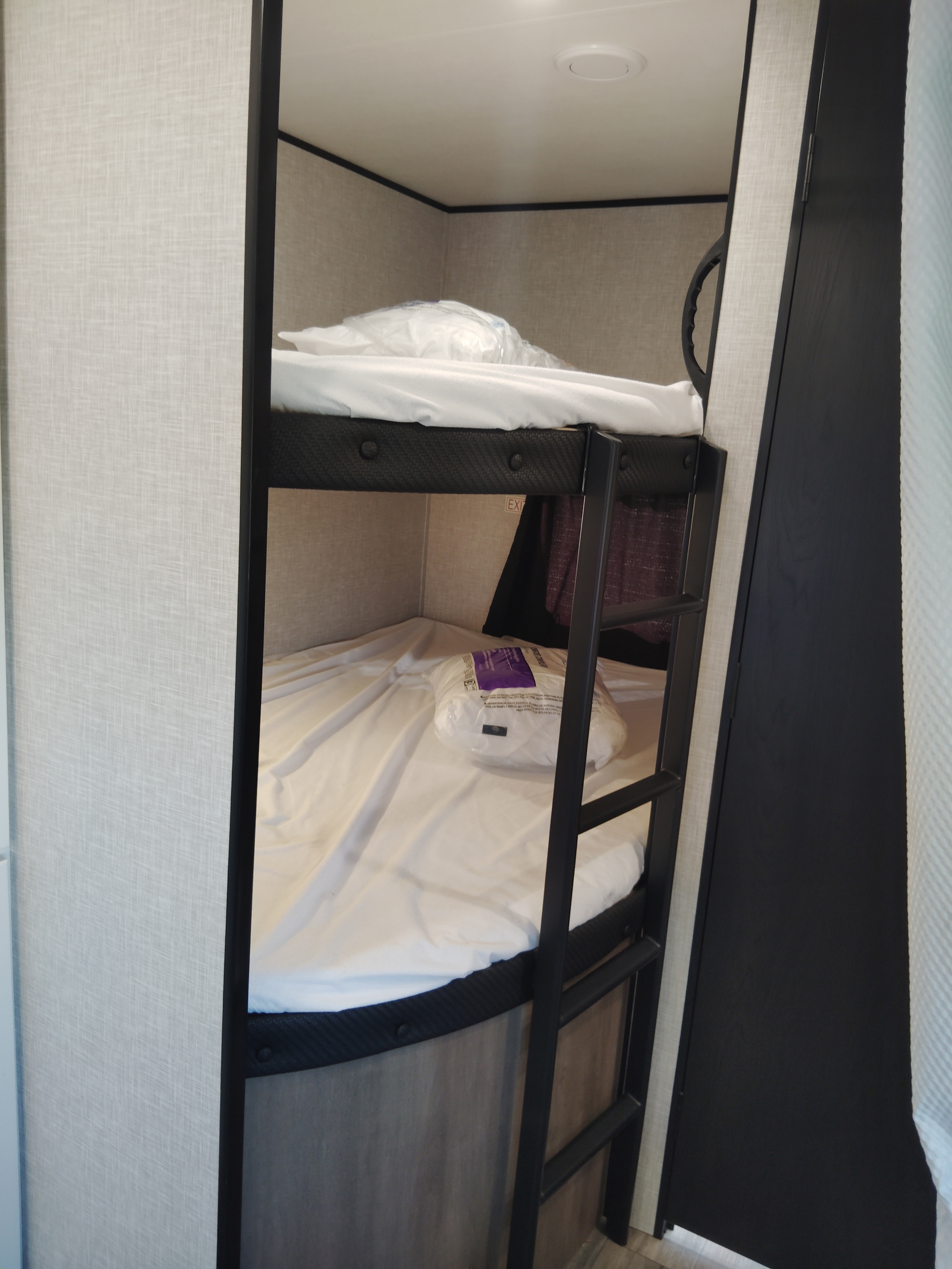 RV rental bunk beds, neatly prepared with white sheets & packaged pillows. A ladder is visible for top bunk access.. Jayco Jay Flight SLX 2025