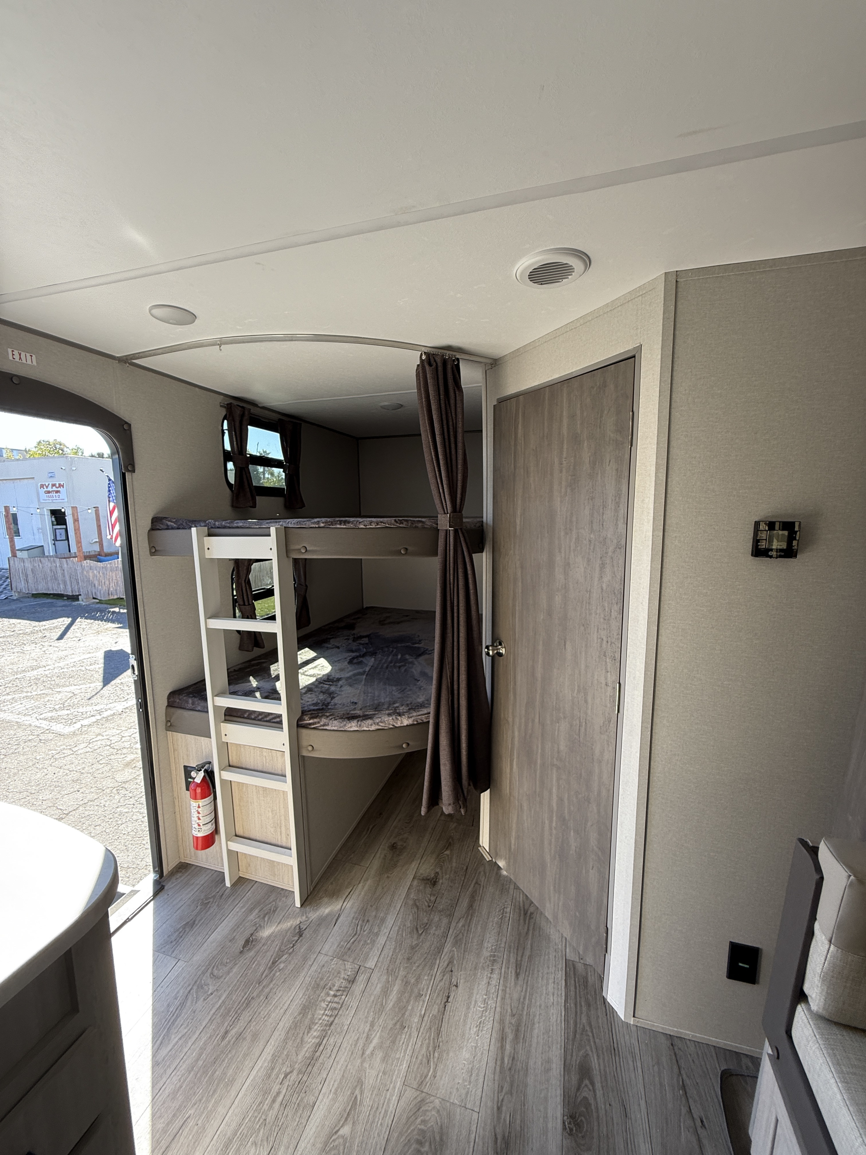 Cozy bunk beds with a ladder and a fire extinguisher are featured in this spacious RV rental interior.. Coachmen Catalina Legacy Edition 2025