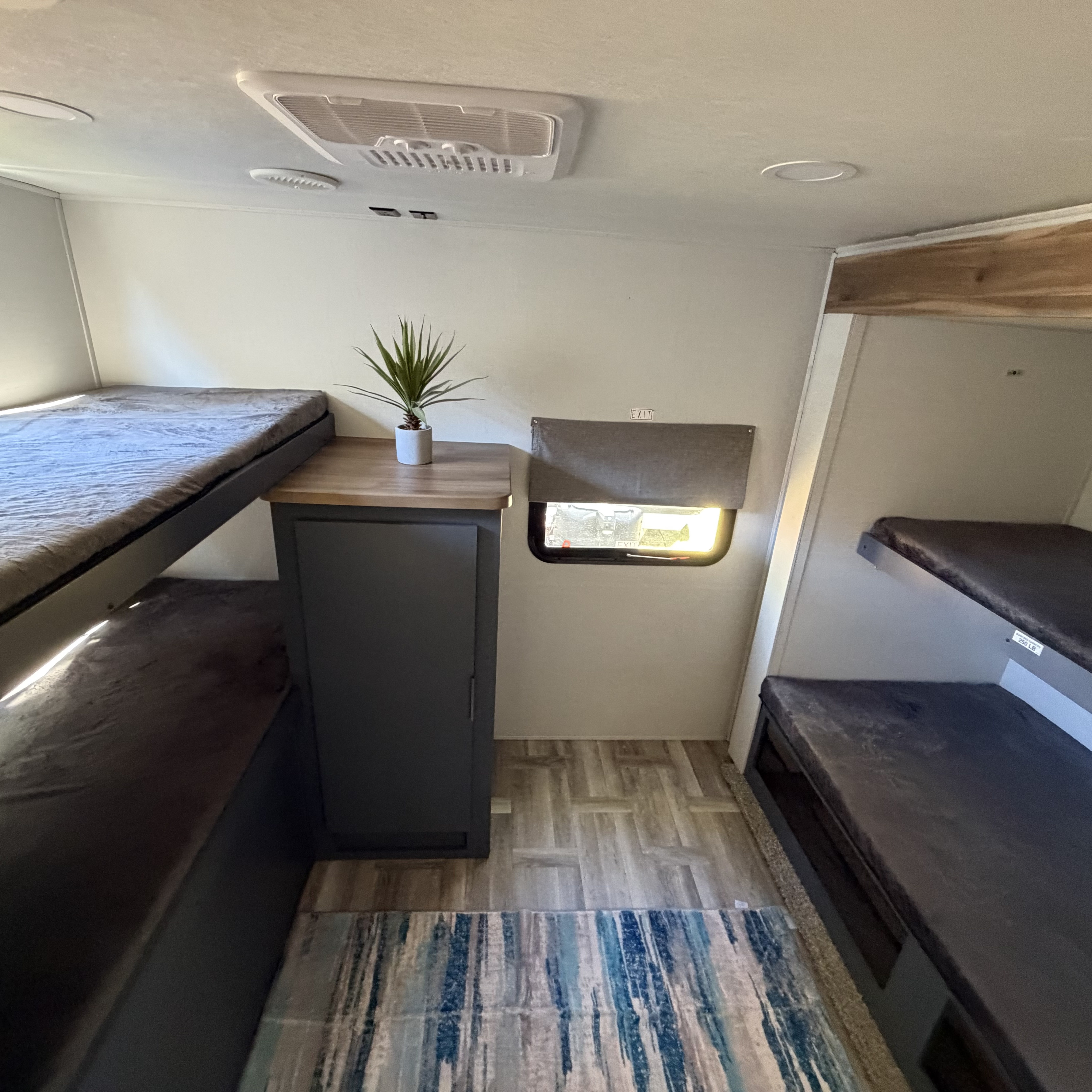 Cozy rv rental bunk room with multiple beds, a small cabinet, and a window for comfortable travel accommodations.. Forest River Tracer Ultra Lite LE 2025