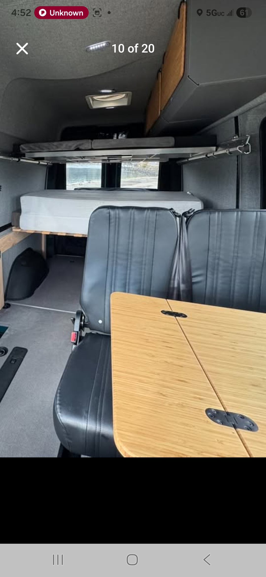 RV rental: Camper van interior with a lower bed, upper bunk, two black seats, and a bamboo folding table.. Mercedes Sprinter van 2500 144 2021