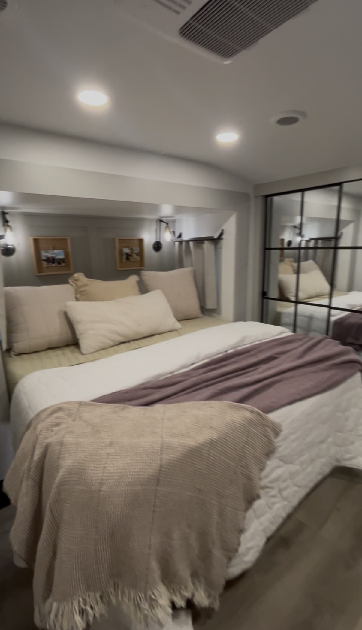 This cozy RV rental bedroom features soft bedding, warm lighting, and mirrored closet doors, perfect for travel comfort.. Brinkley RV Model Z 2025