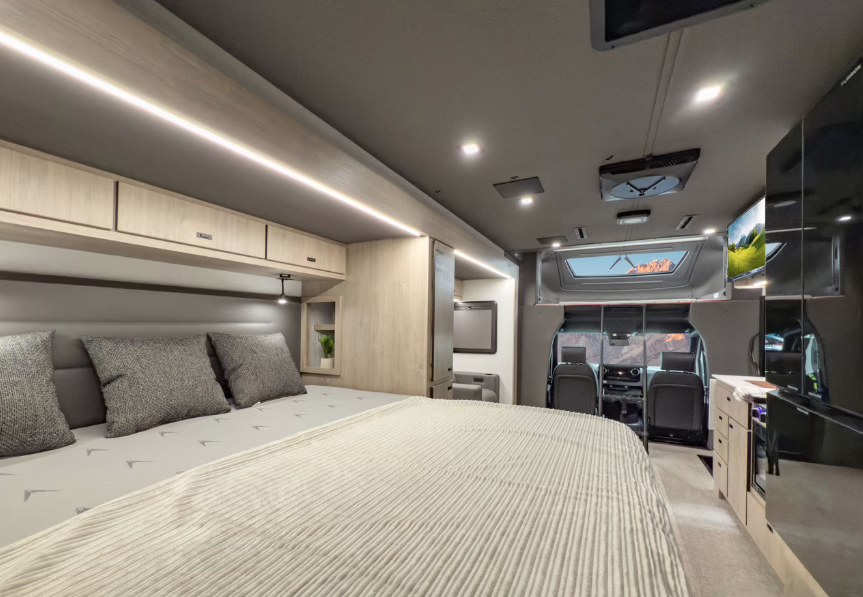 Inside a stylish rv rental: comfy bed, sleek kitchen, and panoramic driver's view for your next adventure.. Grand Design Lineage 2025