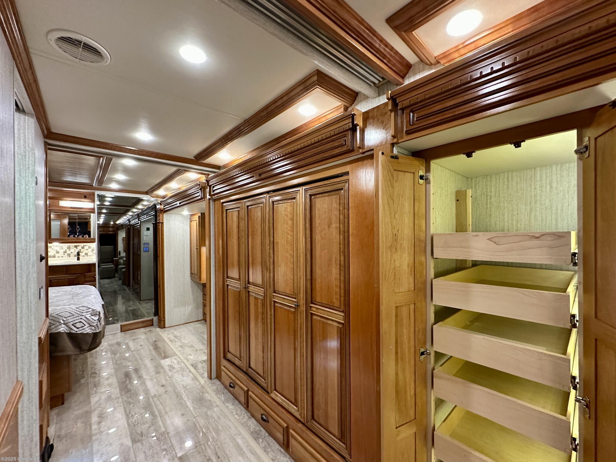 Luxury RV rental features: A detailed look at the hallway with ample wood cabinetry, pull-out pantry drawers, and bright lighting.. Newmar Dutch Star 2019