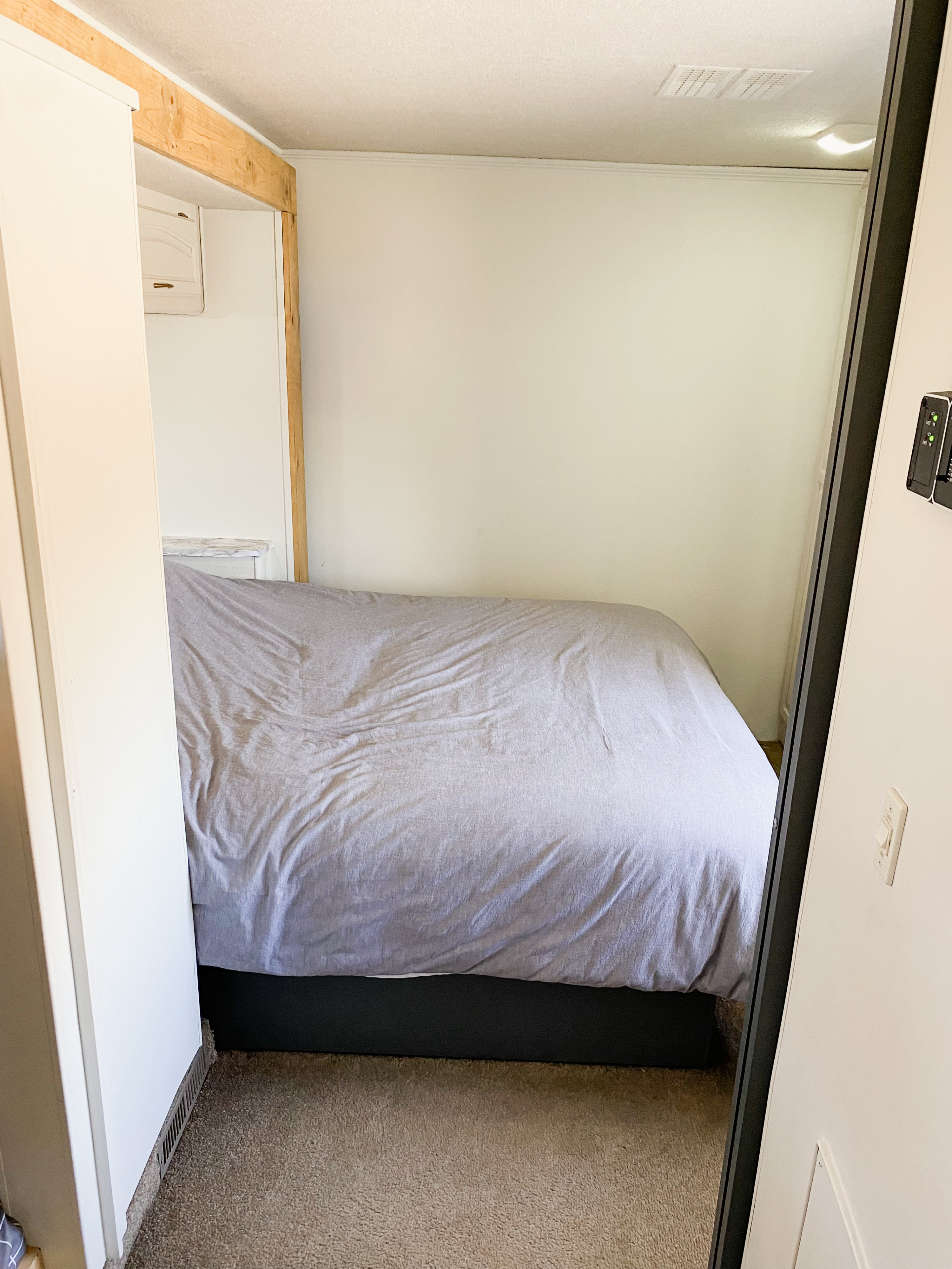Cozy RV rental bedroom. A light-colored duvet covers the bed in this compact space, featuring light walls and carpet flooring.. Fleetwood Fiesta LX 2008
