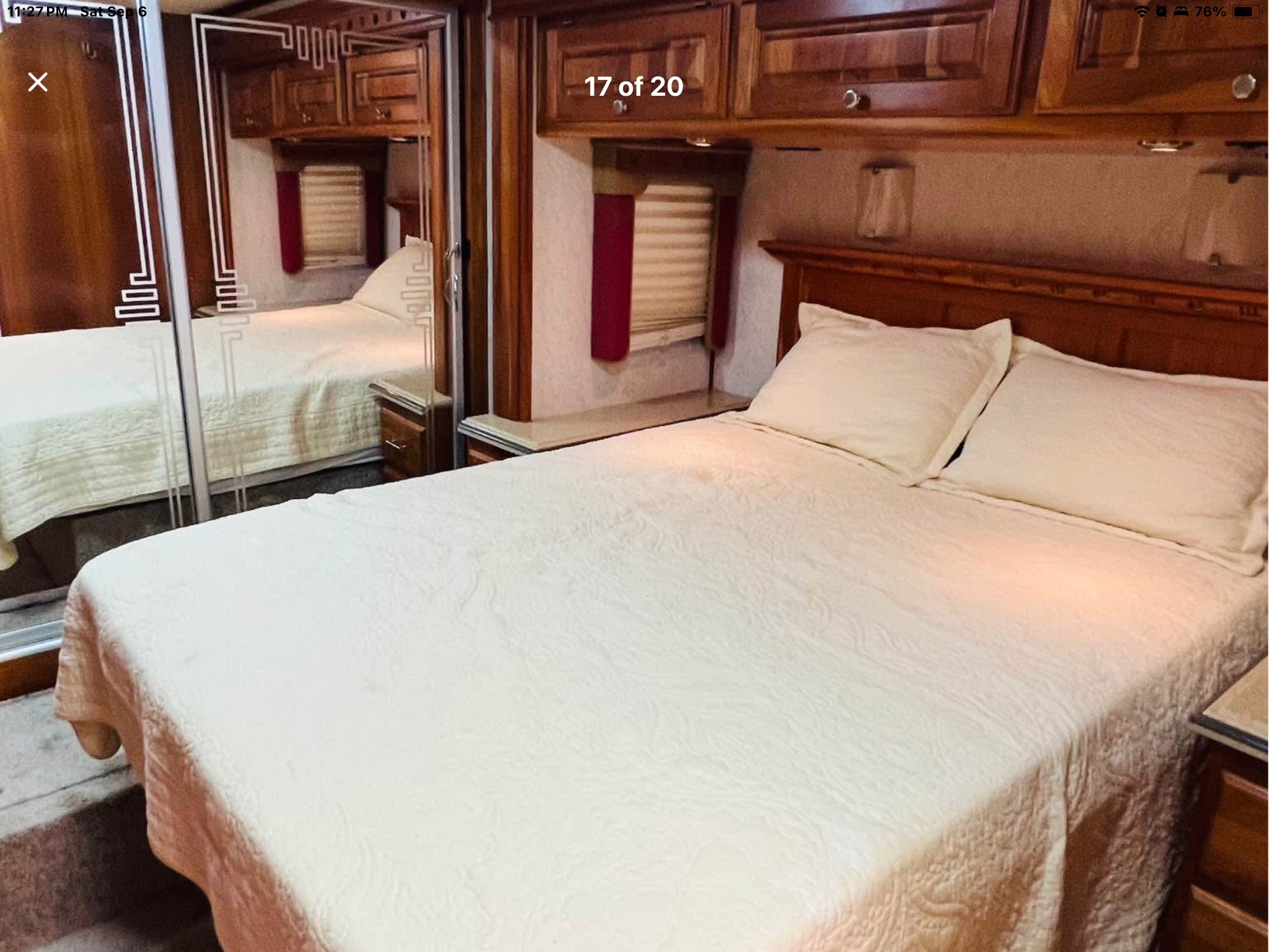 Cozy RV rental bedroom with a spacious bed, quilted bedding, mirrored closet, wood cabinets, and window blinds. Perfect for travel.. Holiday Rambler Scepter 2006