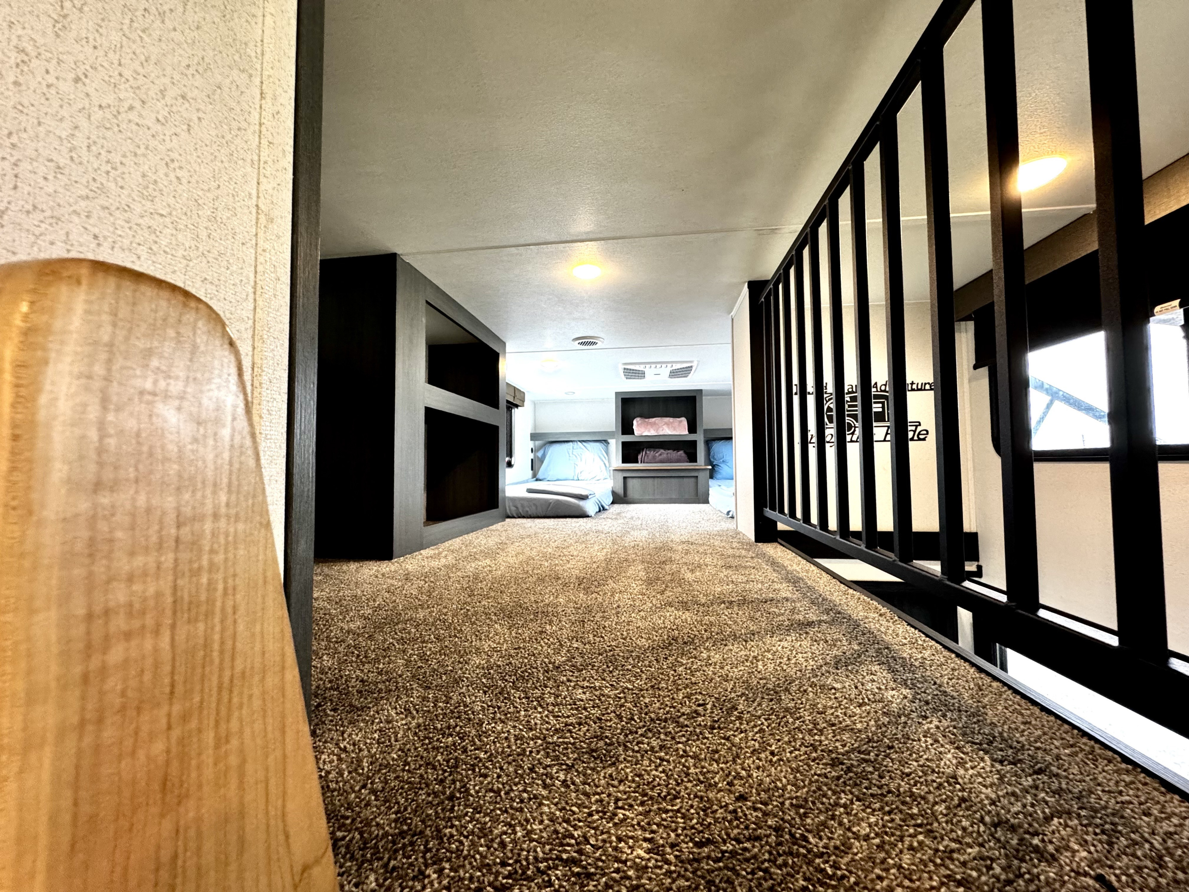 Cozy RV rental loft with carpeted floor, bunk beds, and a safety railing, ideal for family adventures.. Forest River Puma Destination 2025