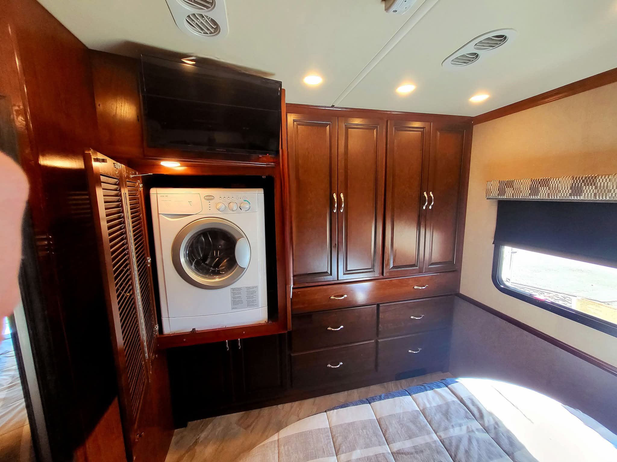 Experience comfort in this rv rental's bedroom, complete with an integrated washer/dryer, TV, and spacious cabinets.. Fleetwood Bounder 2017