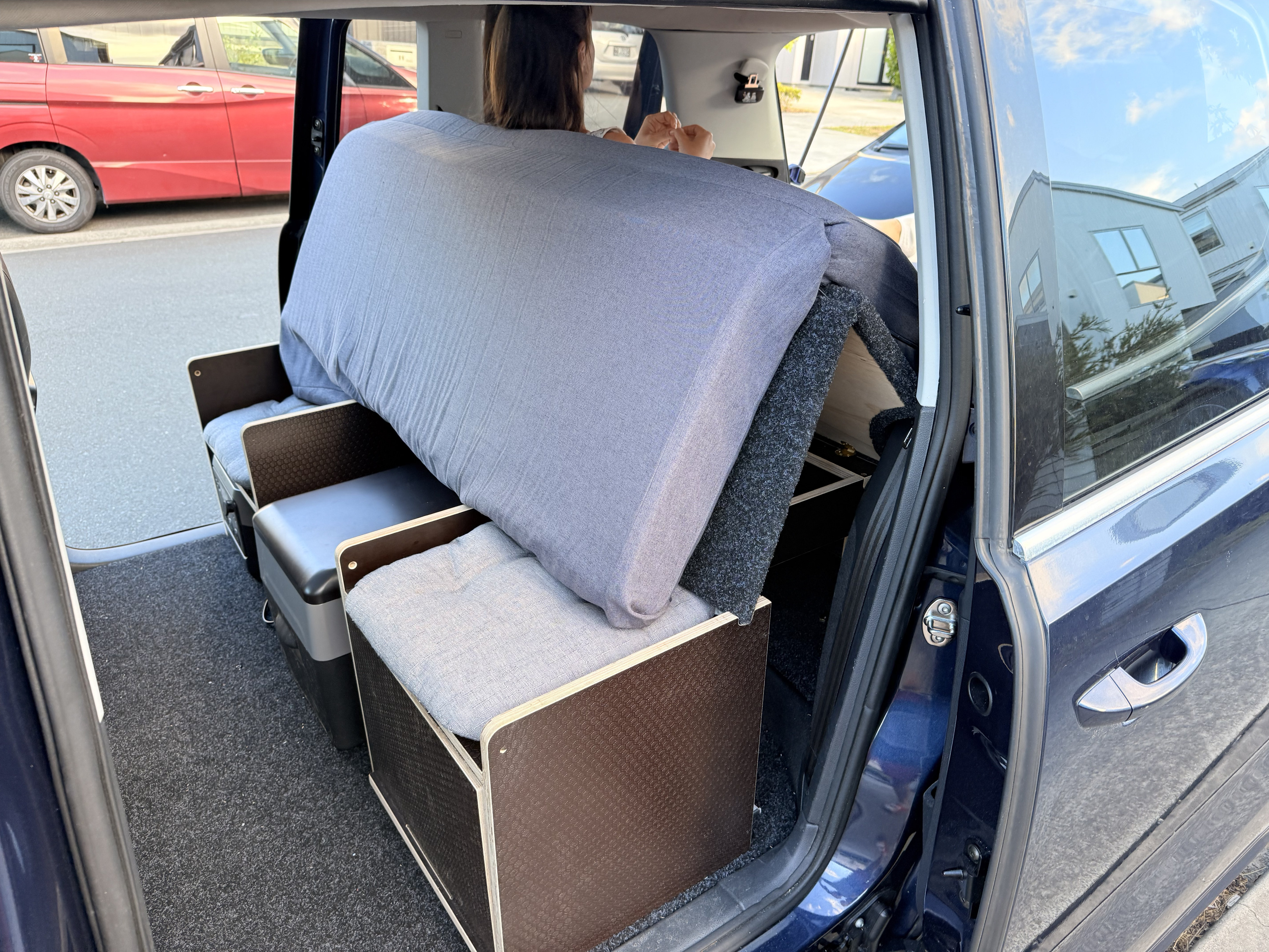 Modular car camping setup in an RV rental, featuring a bed/seating, cushions & cooler. Ideal for travel & van life.. Volkswagen Sharan 2012