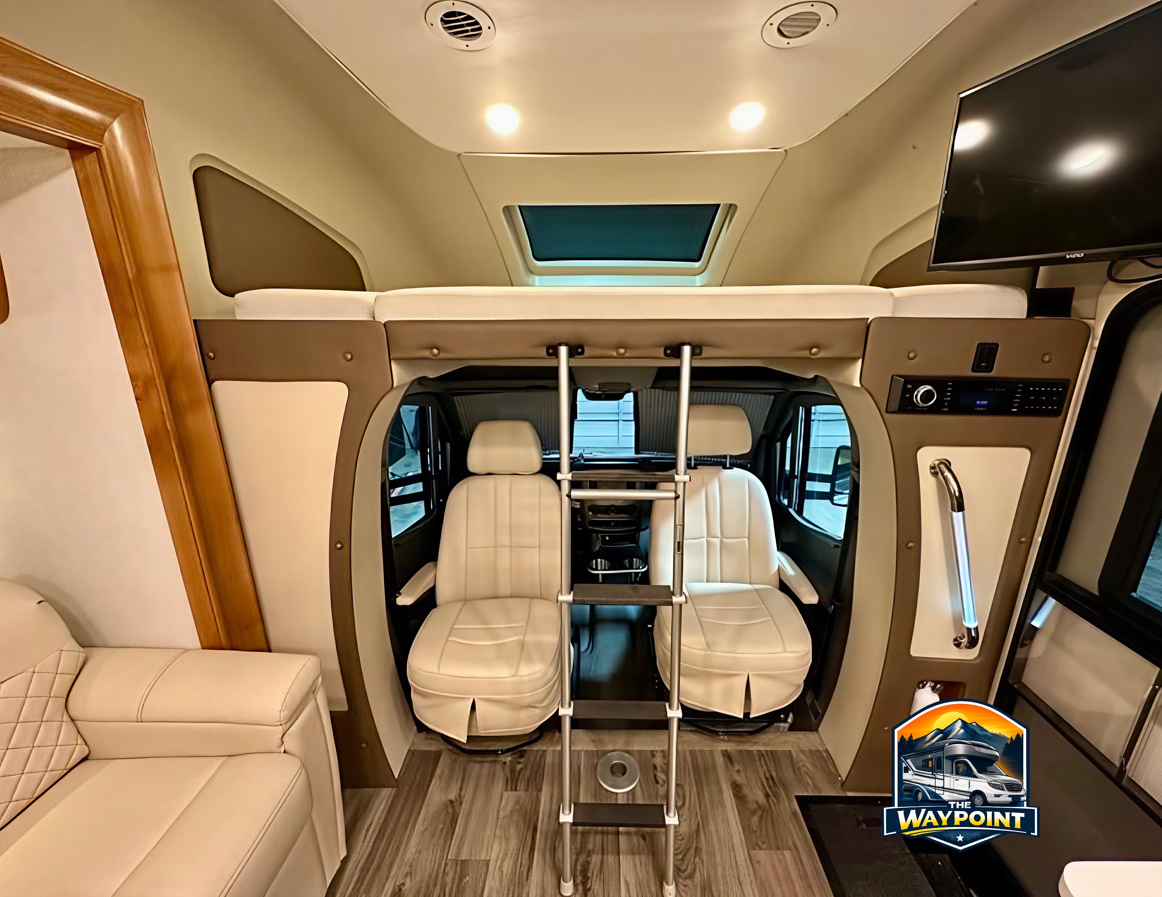 Explore our premium RV rental interior: overhead bunk with ladder, swivel cockpit seats, TV, and plush sofa. Modern comfort awaits!. Wayfarer Wayfarer Motorhome 2019