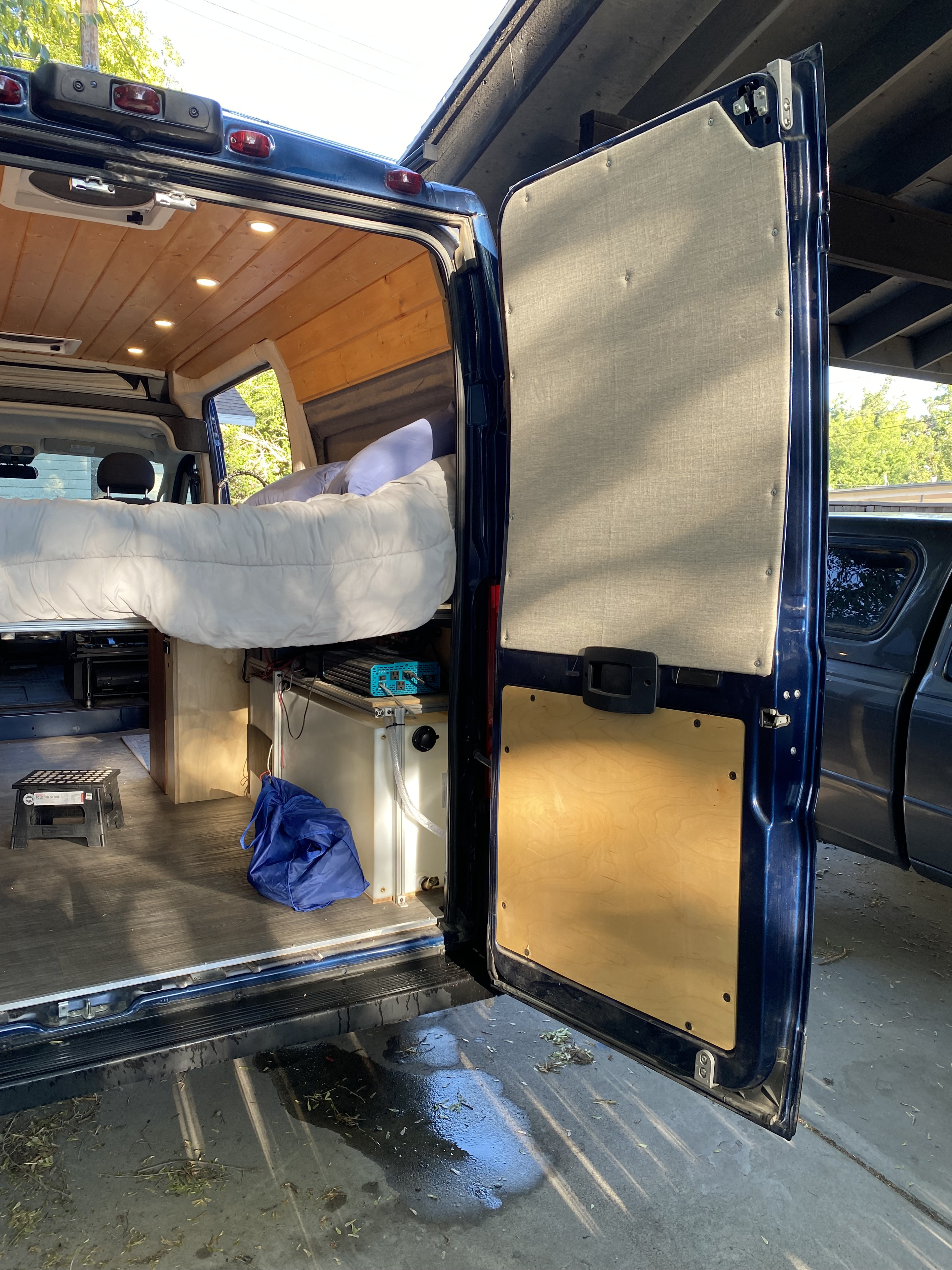 Step into this custom camper van RV rental! Features a cozy raised bed, wood ceiling, & organized utilities.. Custom Camper 2021