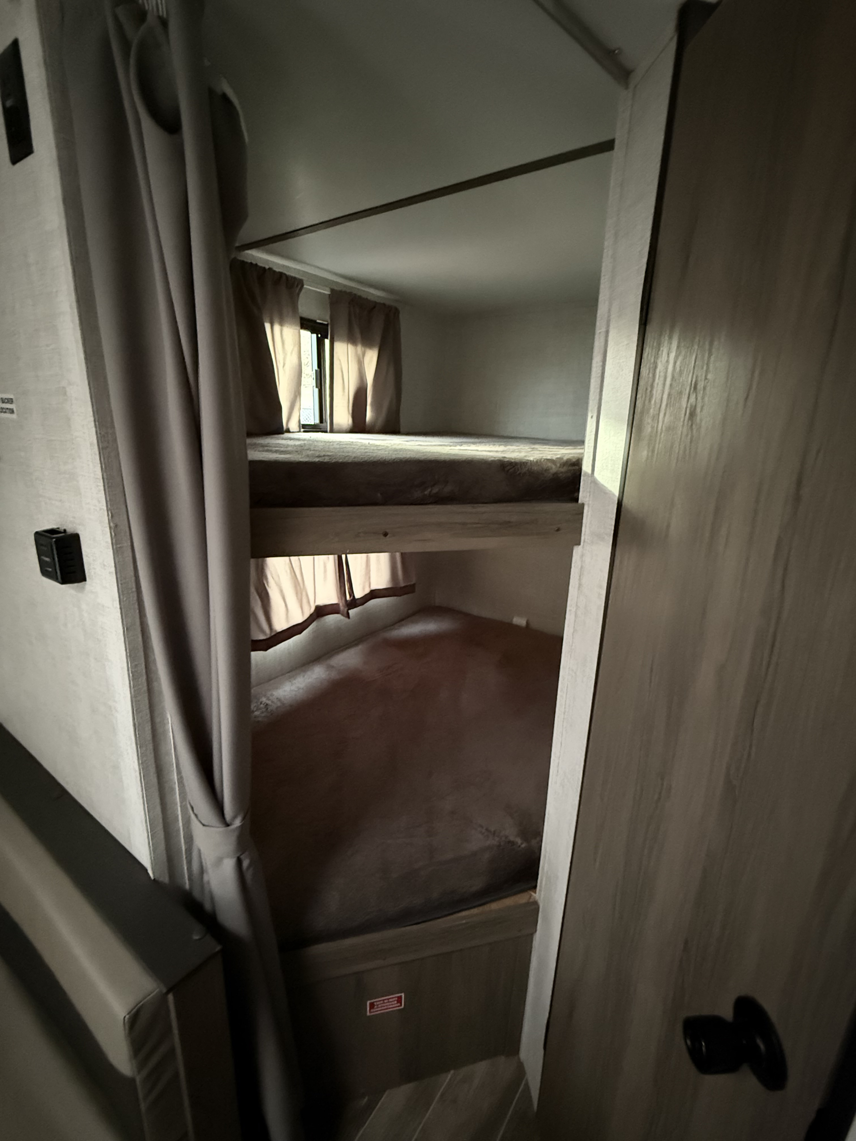 Inside this **rv rental**, dual bunk beds with privacy curtains provide a compact and cozy sleeping area for your adventure.. Gulf Stream Ameri-Lite Super Lite 2023