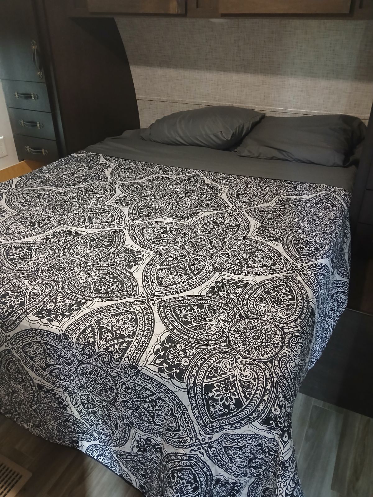 Inside this RV rental, a comfy bed features a black and white patterned comforter and dark gray pillows.. Salem 32BHDS 2020