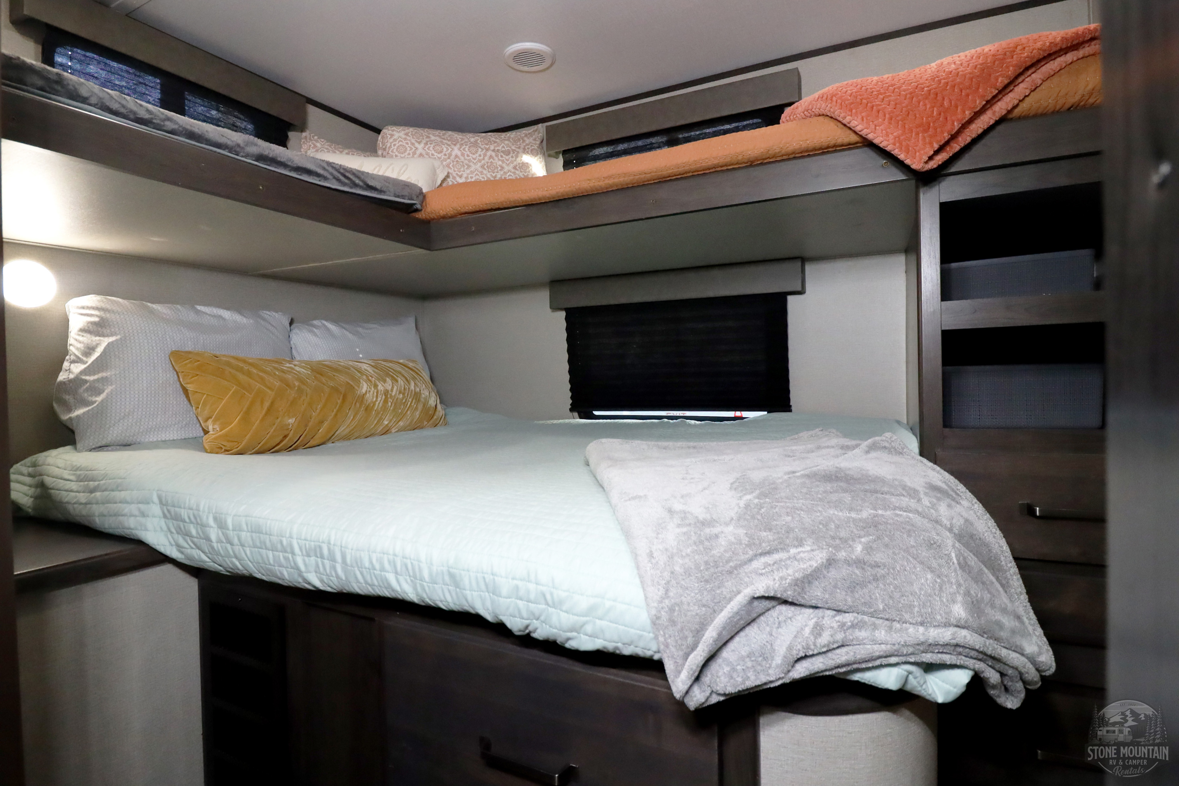 Cozy RV rental bunk bed area with soft bedding, plush pillows, and convenient built-in storage for a comfortable stay.. Grand Design Transcend Xplor 2023
