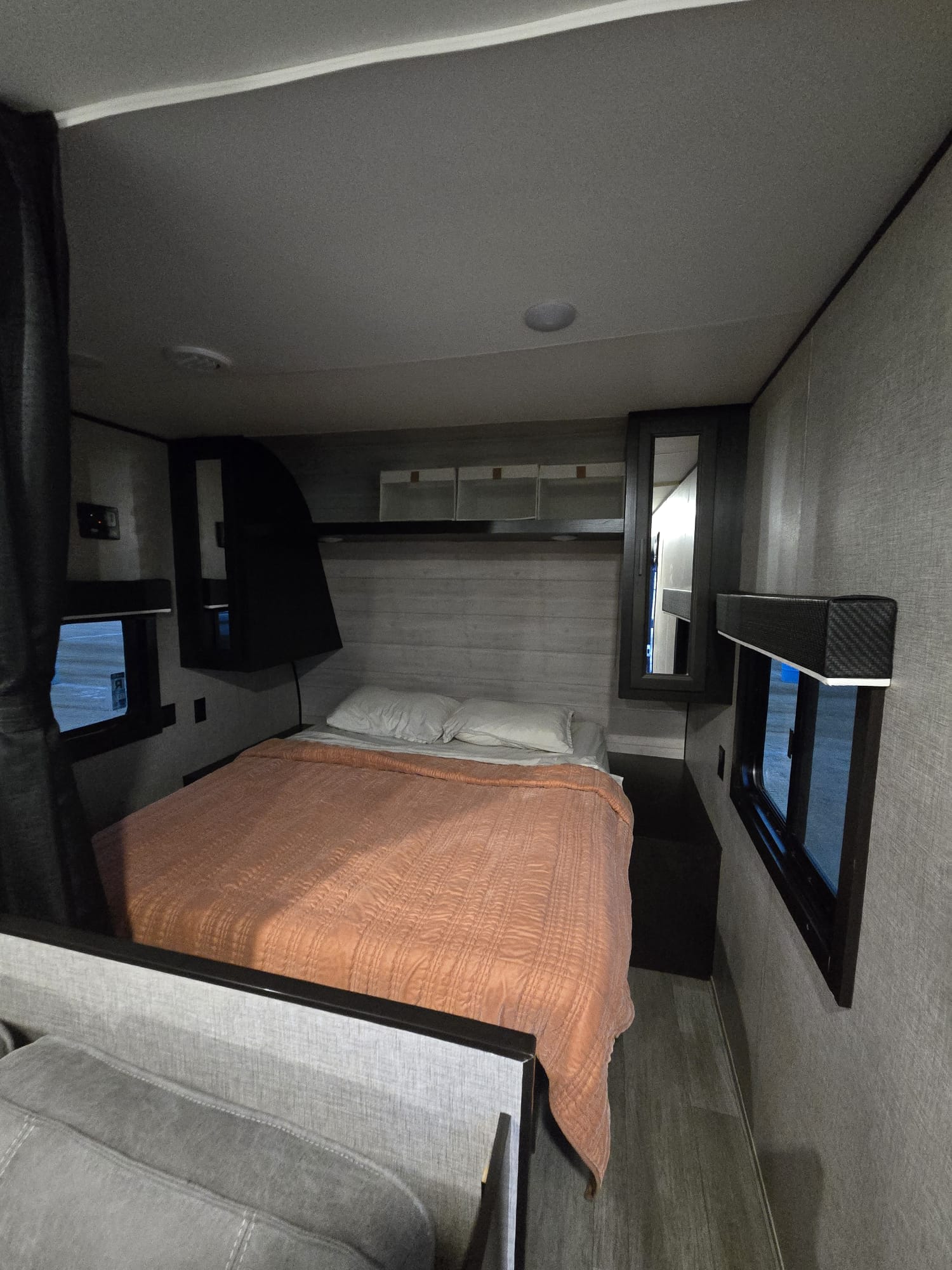 An RV rental's compact bedroom features a bed, two windows, and built-in storage for a cozy stay.. Jayco Jay Flight SLX 2022
