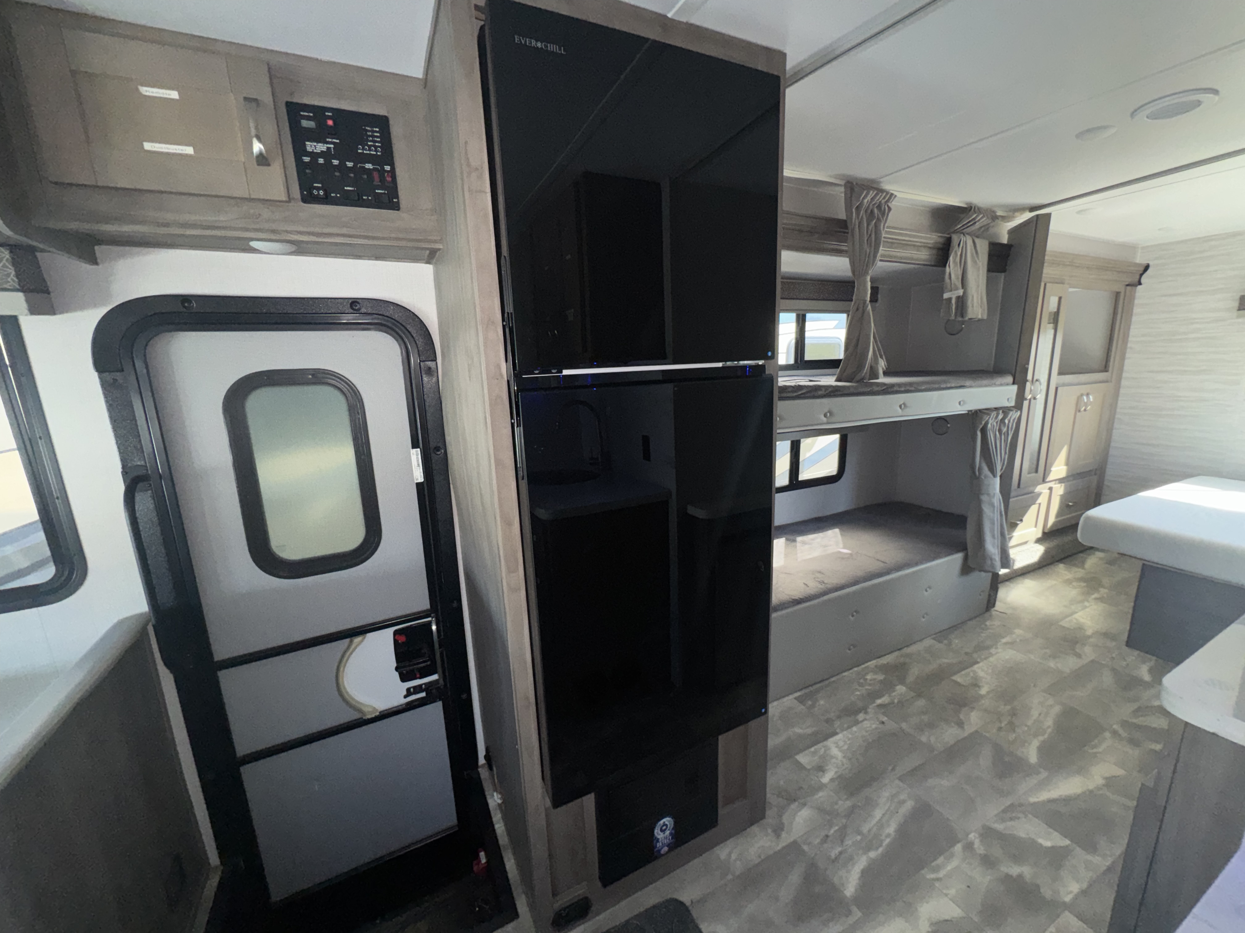 Inside this RV rental, you'll find cozy bunk beds, a sleek EverChill fridge, and a control panel by the entry, perfect for travel.. Gulf Stream 63111 2024