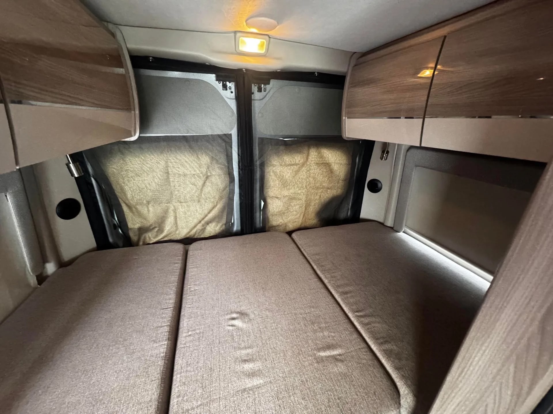 Experience comfort in this **rv rental** interior: a fold-out bed, overhead storage, and screened rear windows for privacy.. Thor Scope 2023