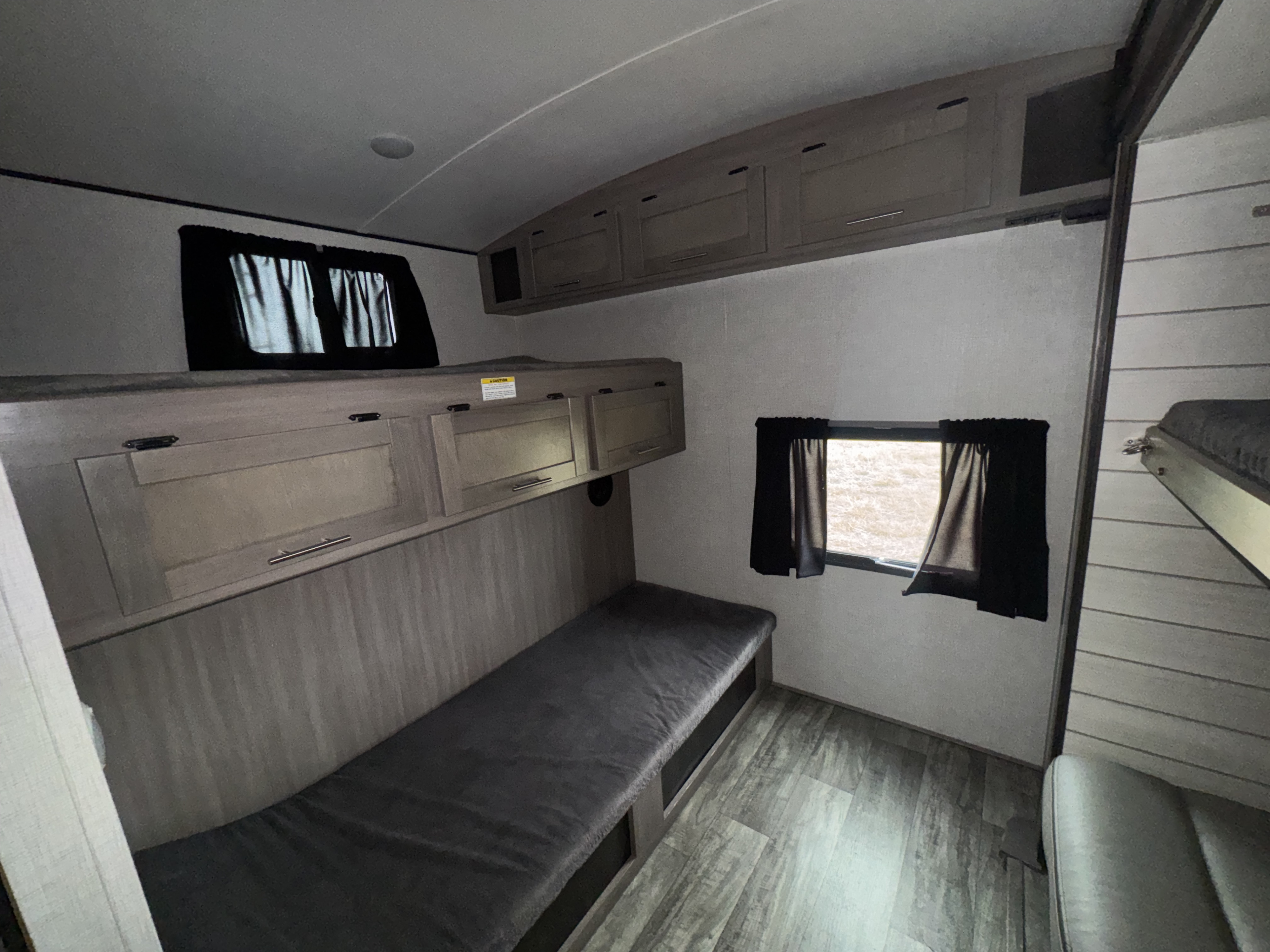 RV rental: Bright bunkhouse interior featuring a lower bunk, overhead storage, and multiple windows, with another bunk to the right.. Crossroads RV Sunset Trail Super Lite 2022