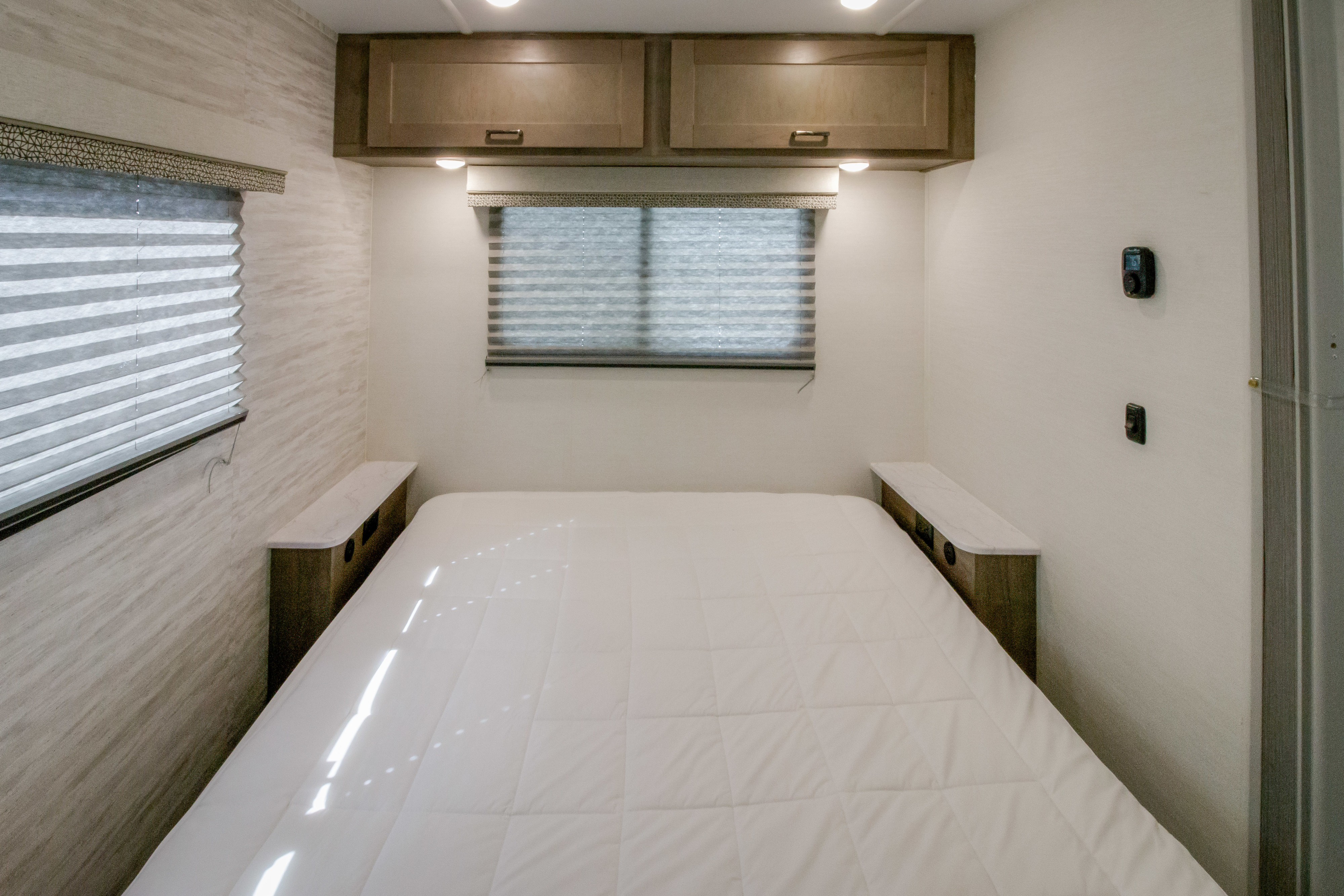 Enjoy a comfortable RV rental experience in this compact bedroom with a cozy bed, storage cabinets, and window blinds.. GULFSTREAM CONQUEST 2025