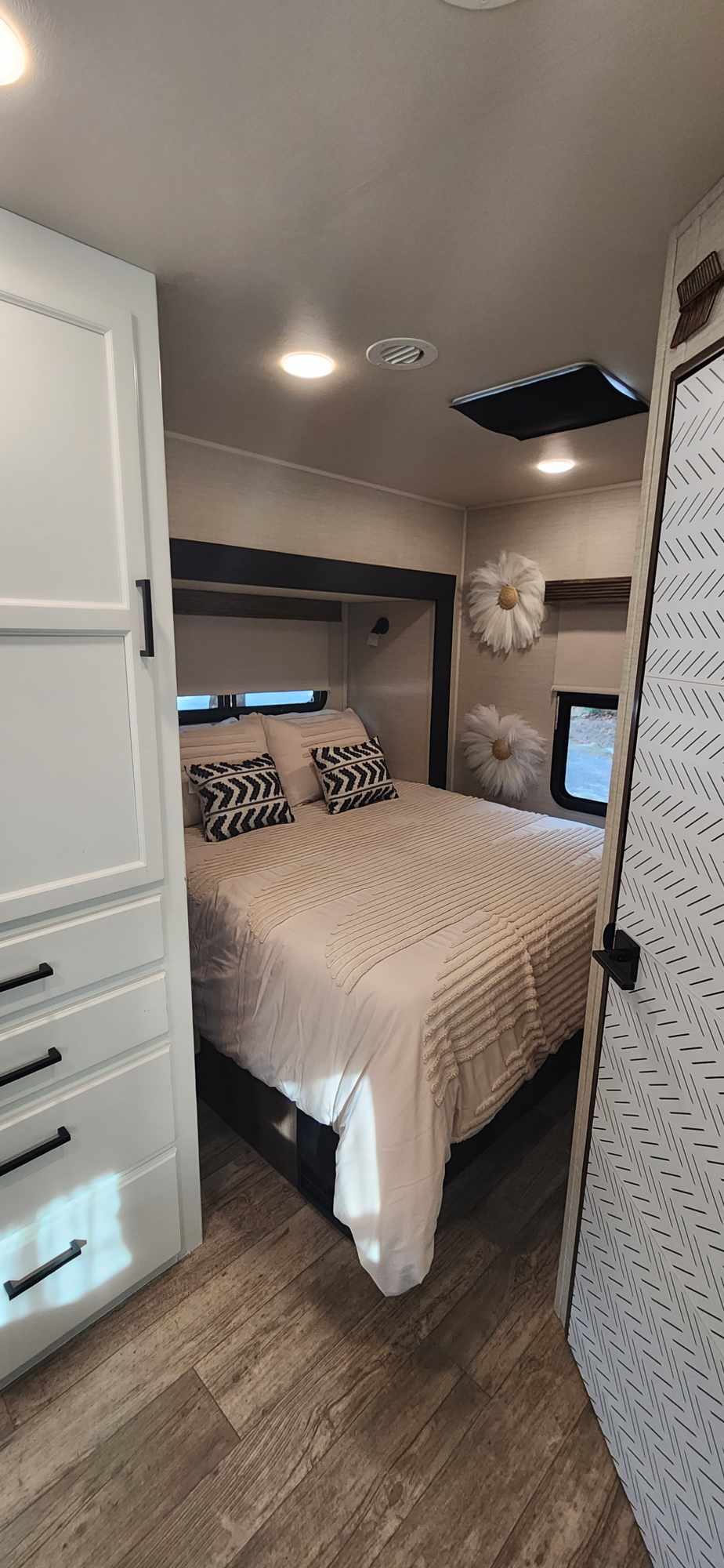 This cozy rv rental bedroom offers a comfortable bed, patterned pillows, and practical storage in a stylish interior.. Jayco Redhawk 2017