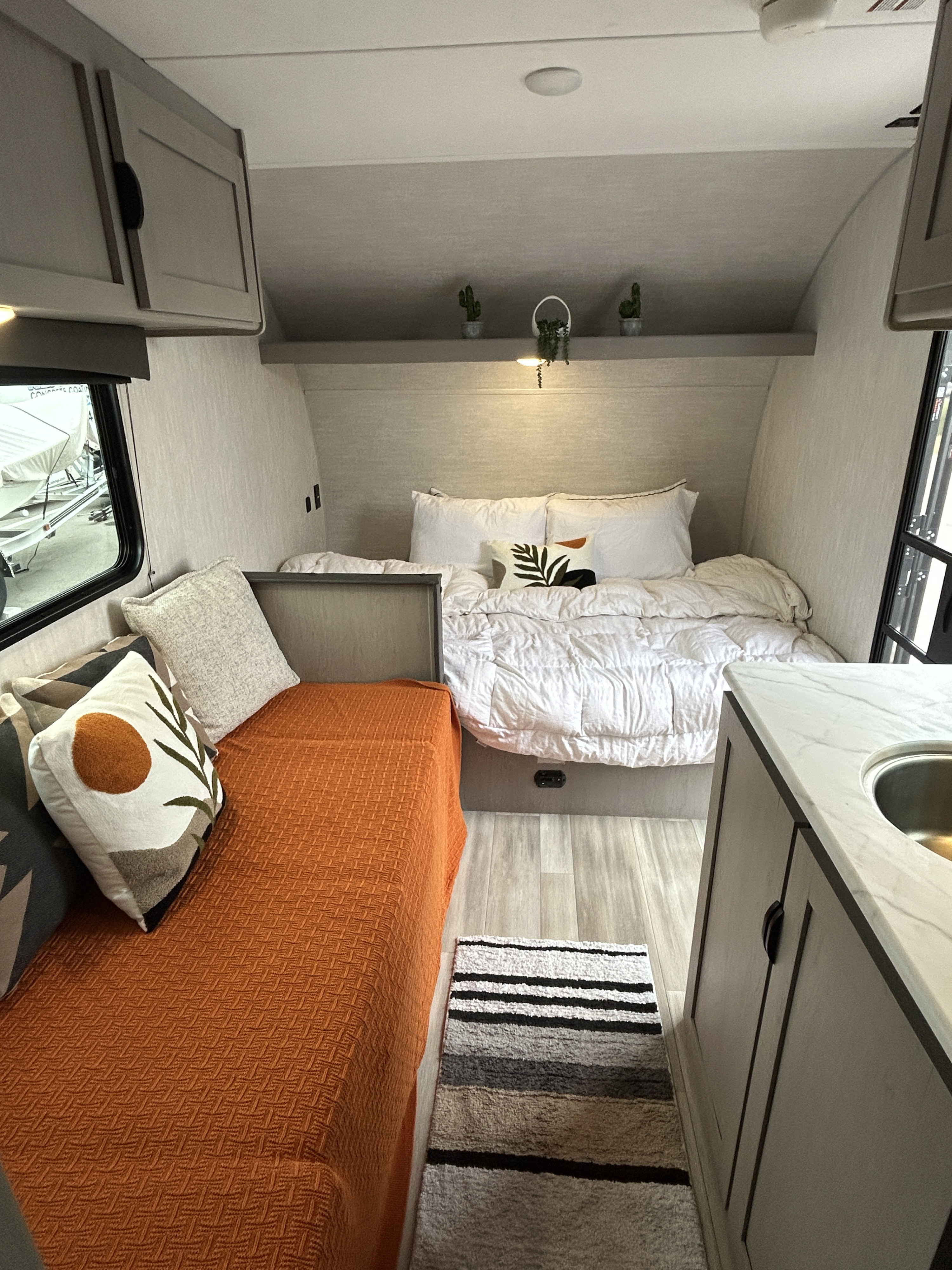 A well-appointed rv rental interior featuring a bed, daybed, and kitchenette, designed for comfort and travel.. Coachmen Clipper 2025