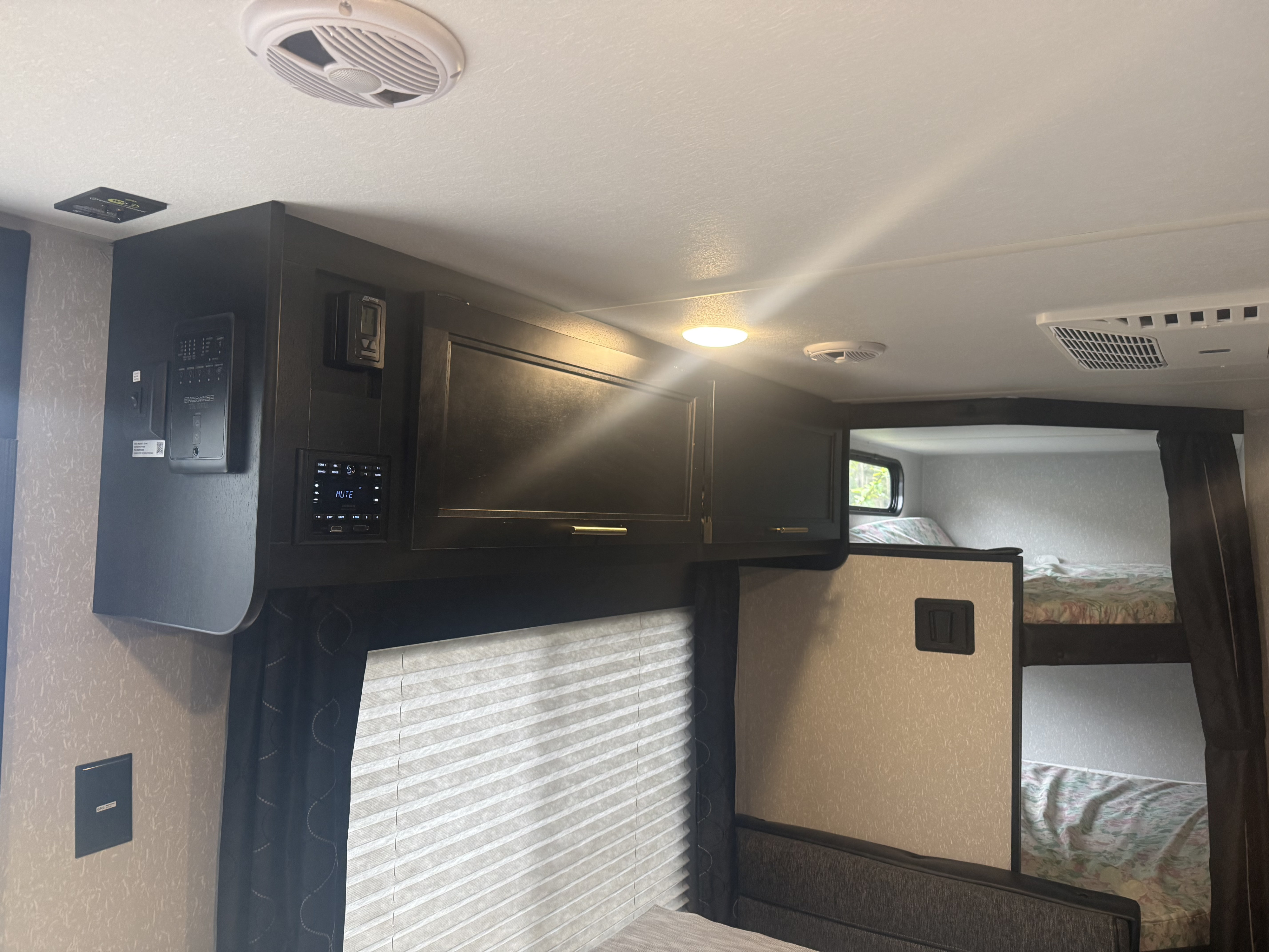 This RV rental's interior features a control panel, media system, overhead cabinets, and bunk beds, perfect for family trips.. Forest River Cherokee Grey Wolf 2022