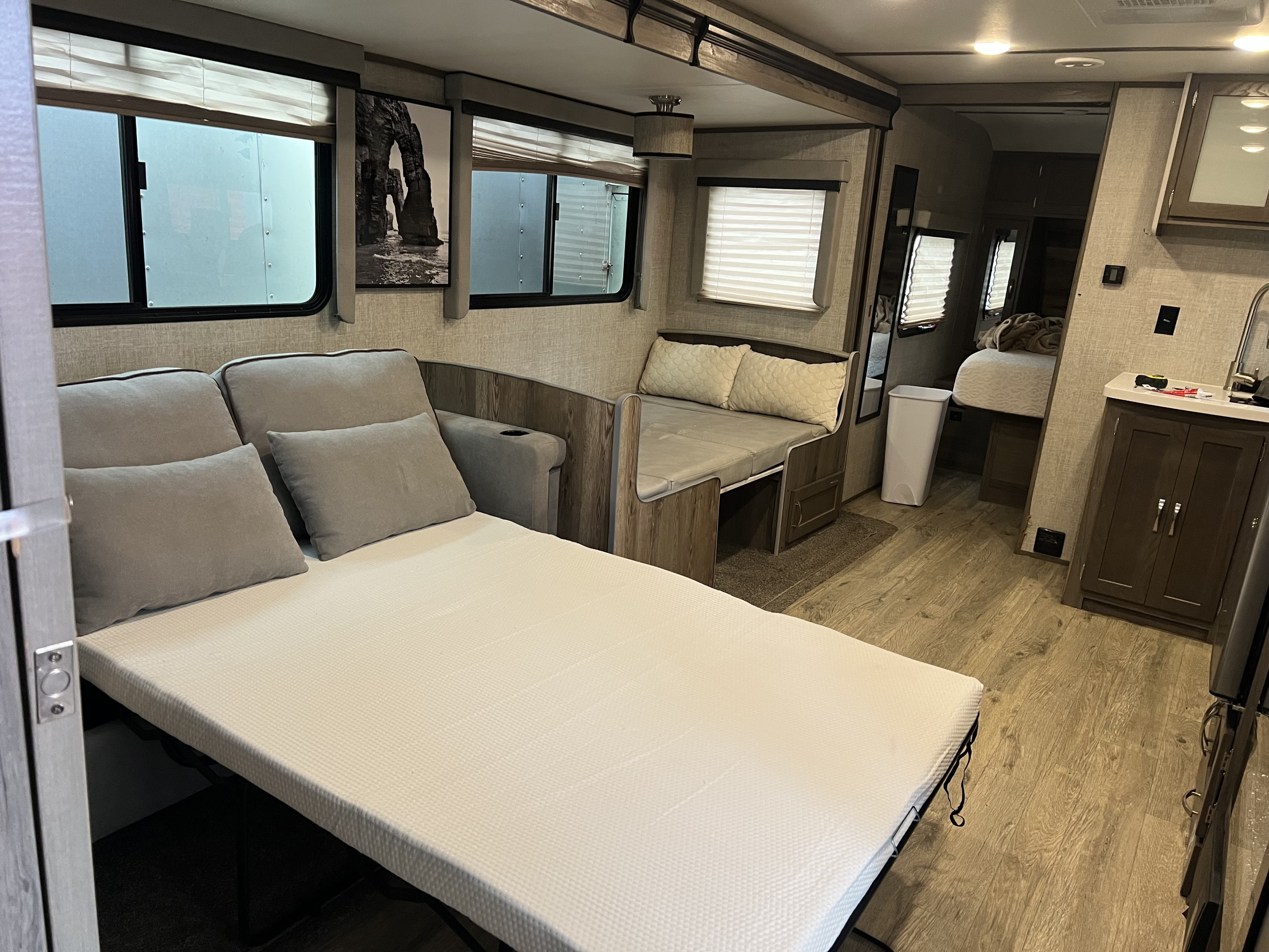 Comfortable RV rental interior: sofa converts to a bed, alongside a dinette & compact kitchen. Ideal for trips.. Gulf Stream Envision 2021