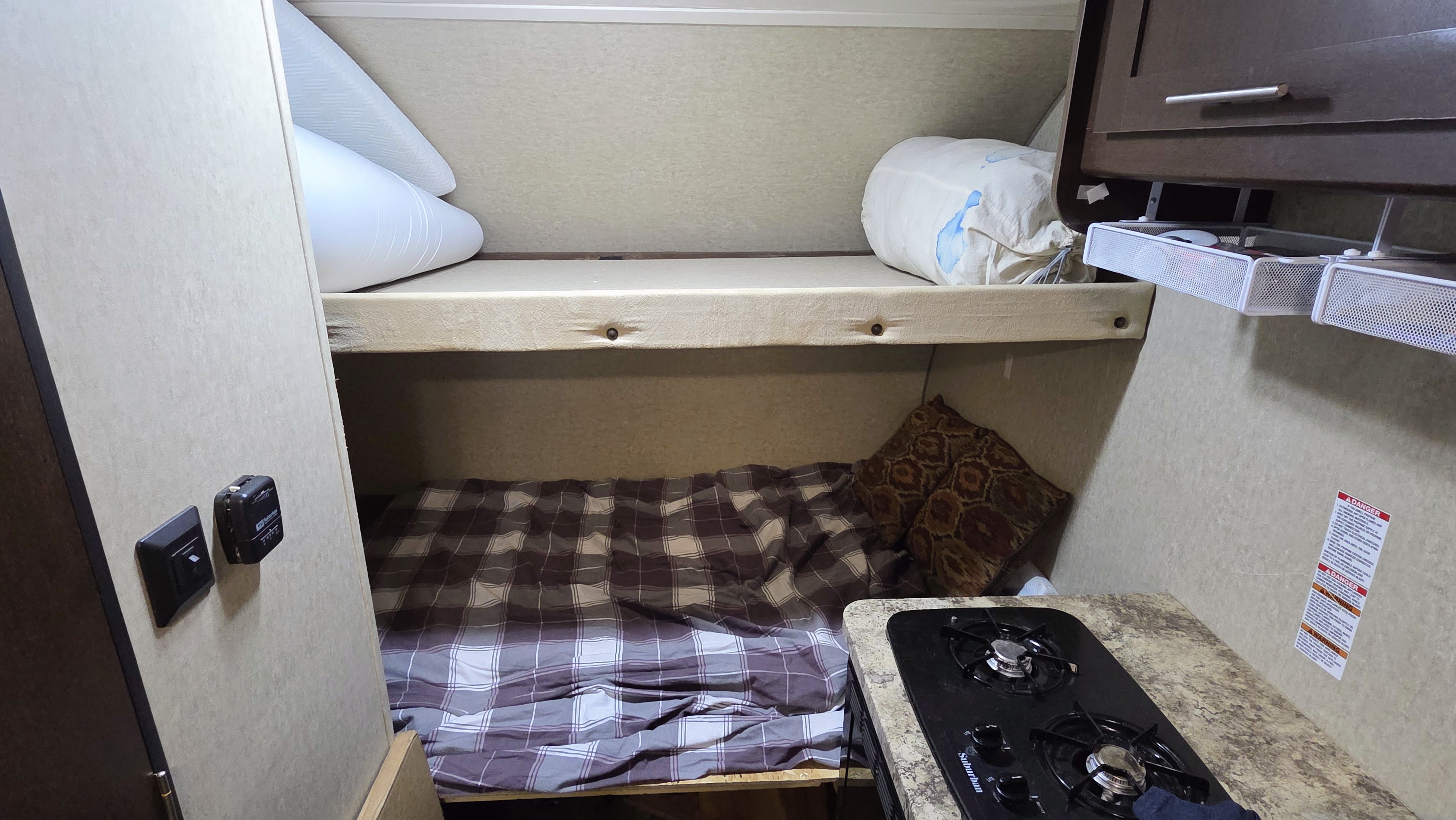 Cozy rv rental interior with bunk beds, a compact kitchen, and storage solutions for your travel adventures.. Forest River Cherokee Wolf Pup 2016