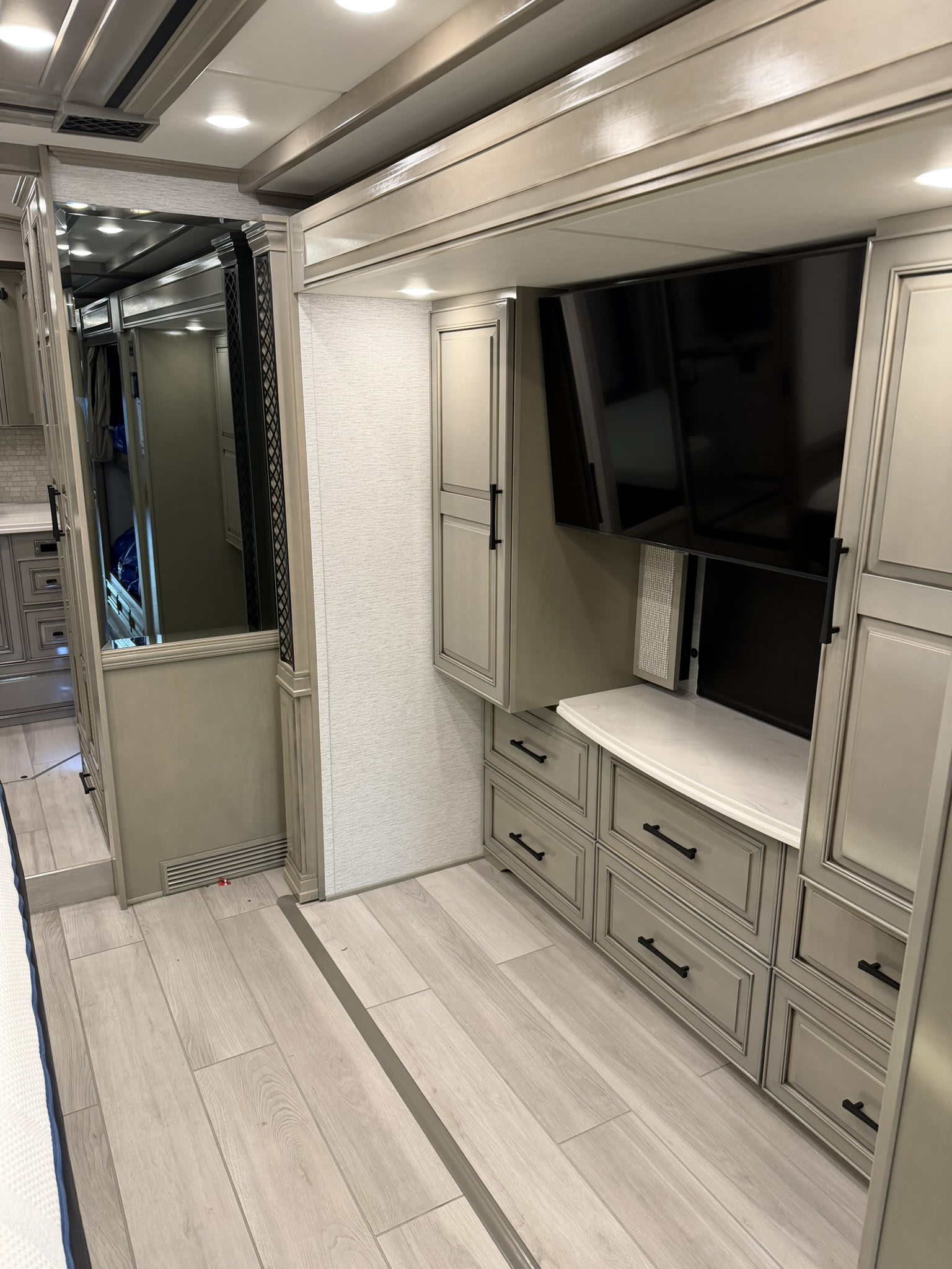 Modern RV rental: detailed cabinetry, mounted TV, light wood flooring, and a mirrored passage.. London Aire London Aire Motorhome 2024