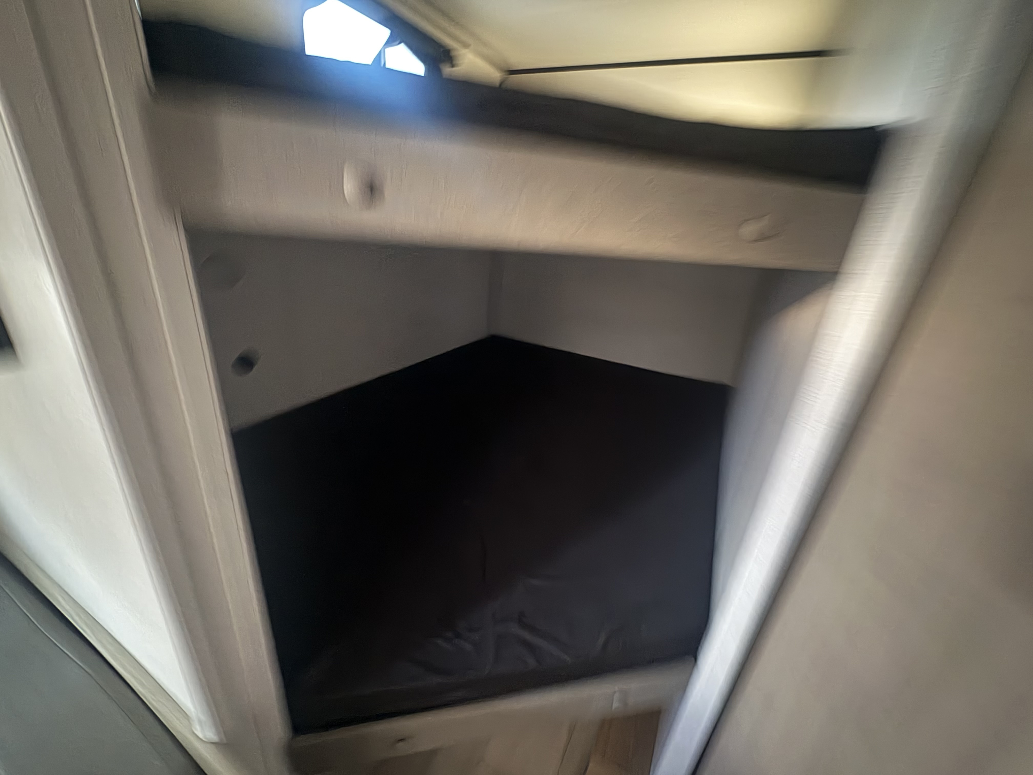 RV rental interior: a cozy bunk bed with a dark mattress and light walls, illuminated by an overhead light source.. Keystone RV Coleman 2025