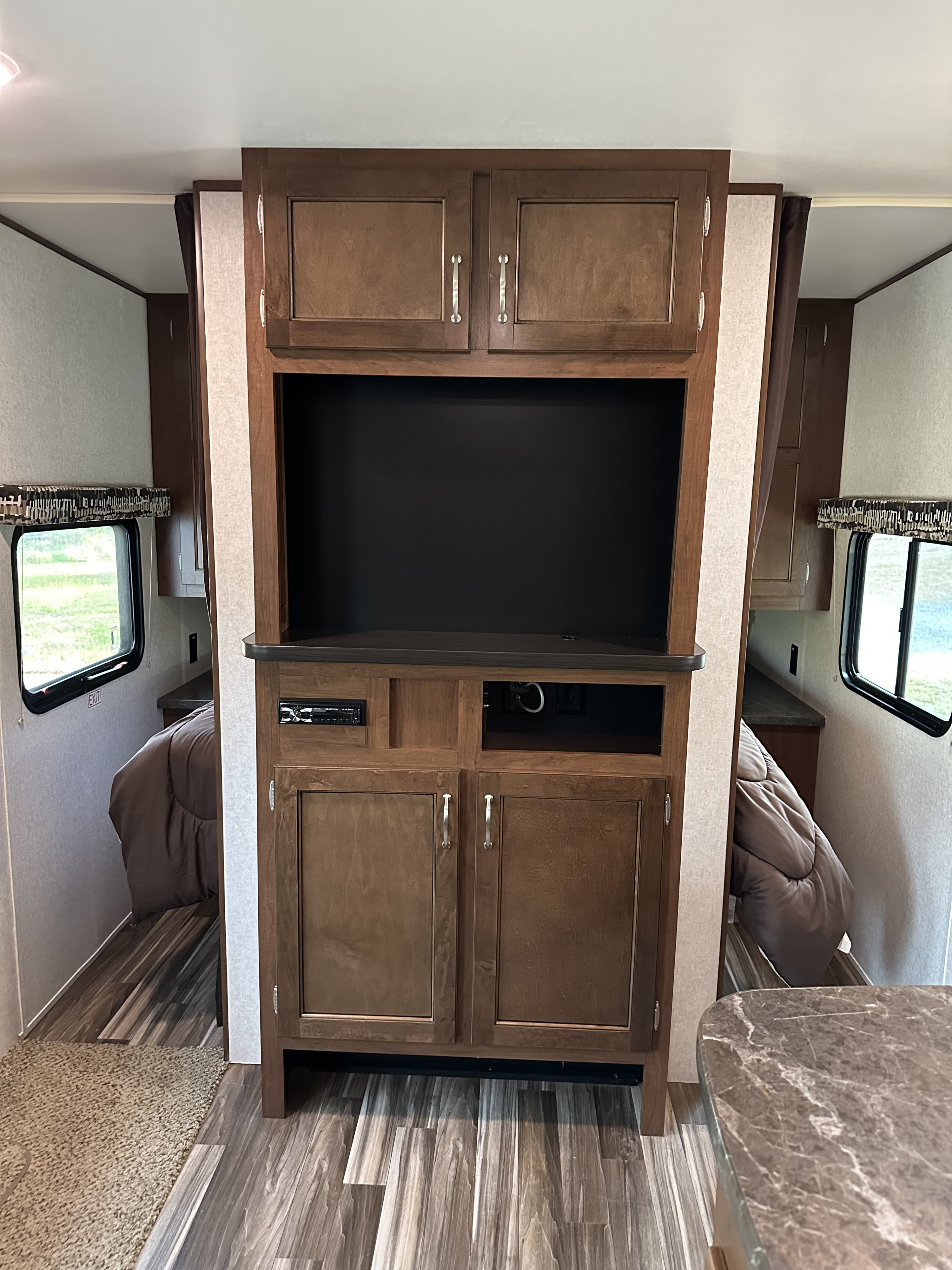 Inside this RV rental: a central entertainment unit with TV space & storage, flanked by private sleeping areas.. Jayco Jay Flight SLX 2017