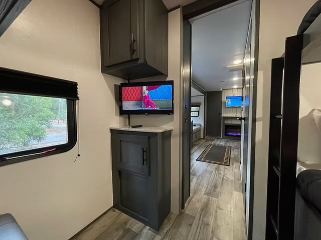 RV rental interior: hallway leading to living area with fireplace, bunk beds, and multiple TVs for entertainment.. Aspen Trail LE 2023