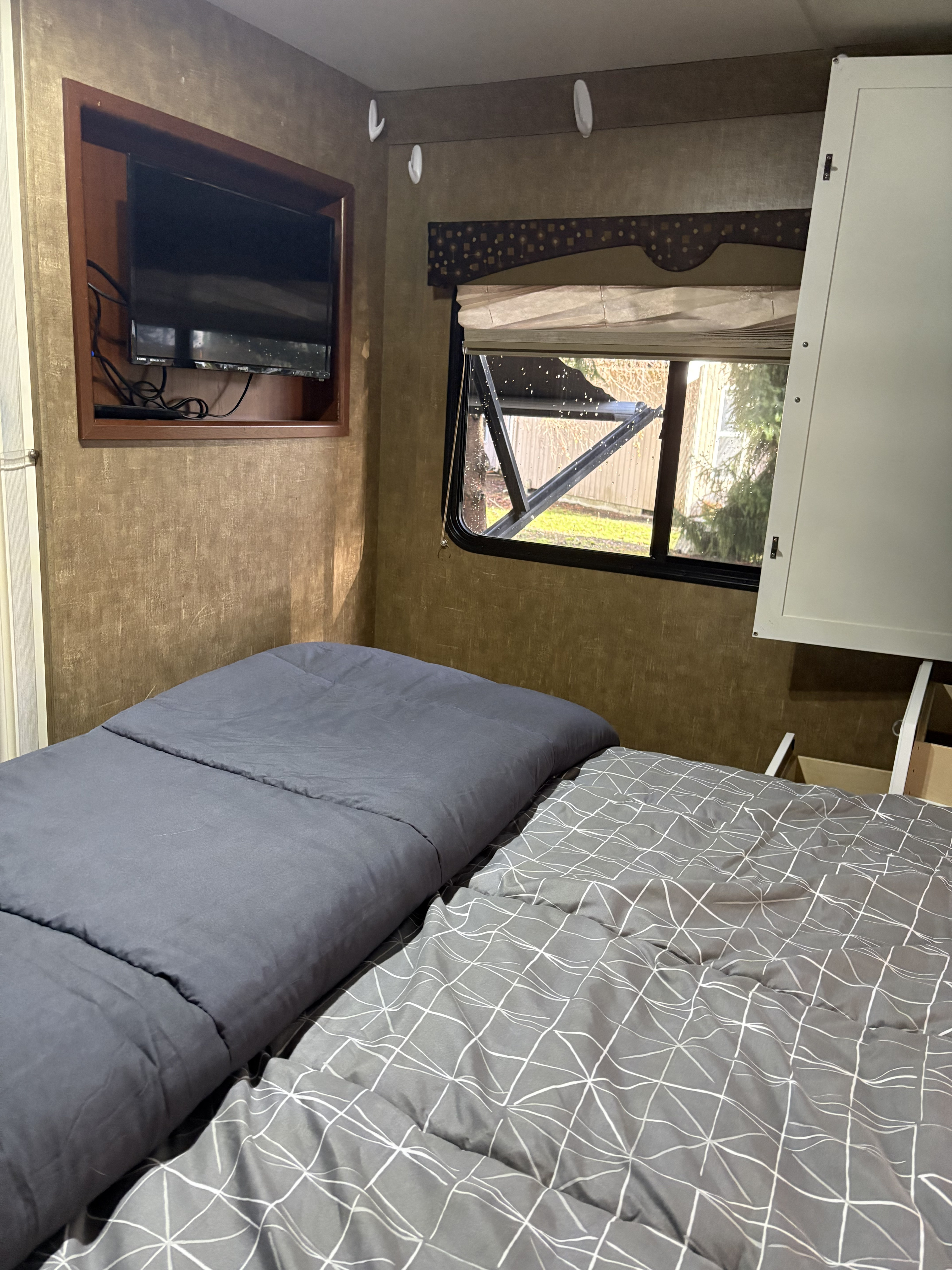 This RV rental offers a compact sleeping area with two beds, a mounted TV, and a window for natural light.. Thor Freedom Elite 2014