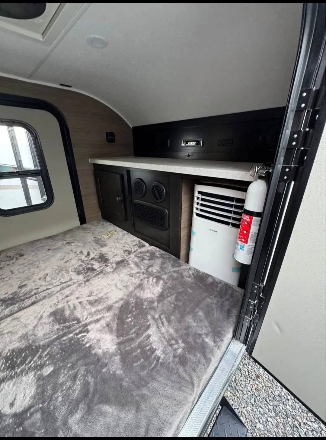 This compact rv rental offers a cozy bed, window, built-in storage, portable AC unit, and fire extinguisher for safety.. Braxton Creek Bushwhacker 2023
