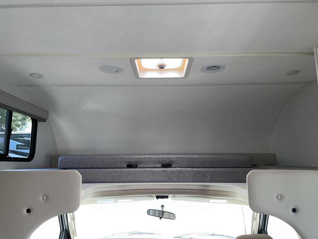 Inside this bright rv rental: a cozy cab-over bunk bed, ceiling lights, air vents, and a window for comfortable travel.. Thor Geneva 28VT 2026