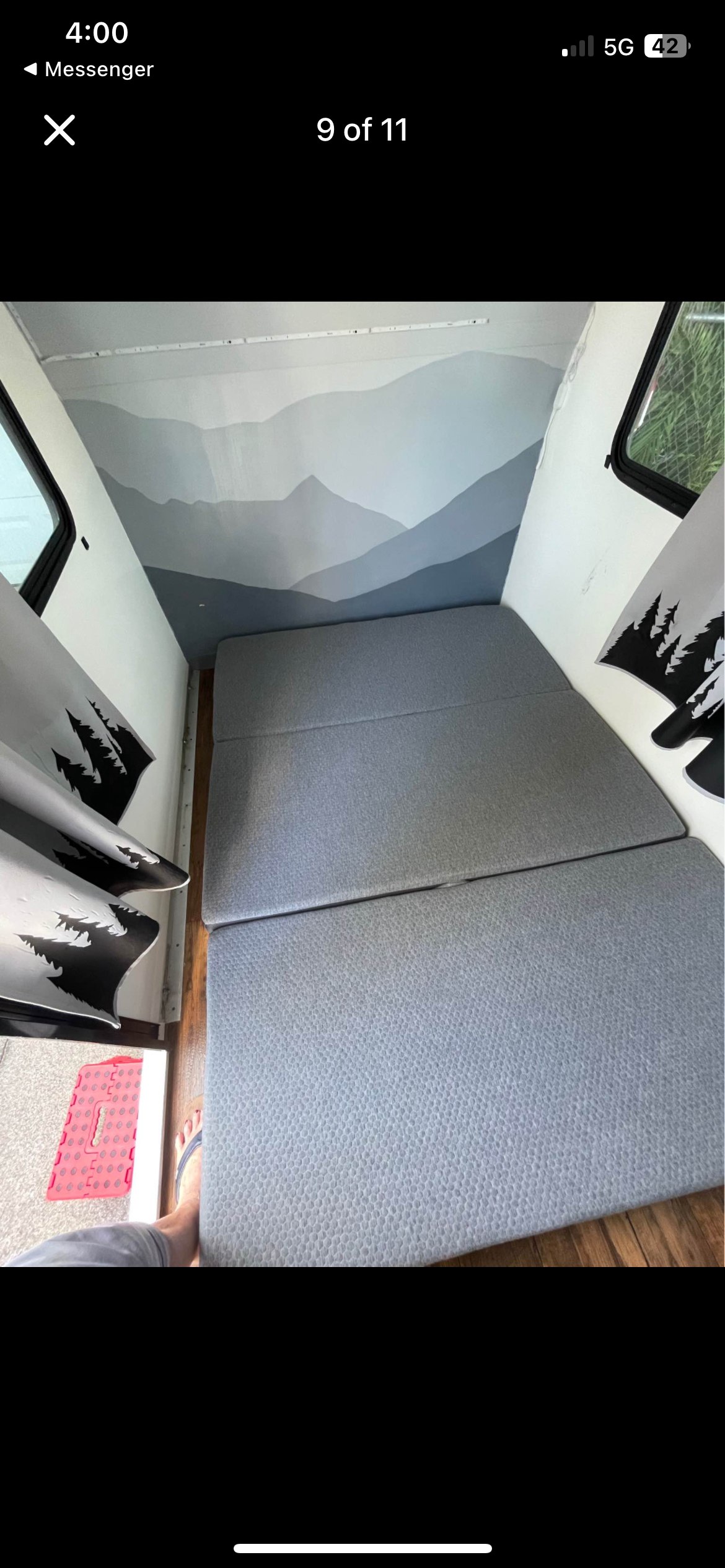 Cozy RV rental interior with a foldable bed, mountain mural, tree curtains, and a step stool.. Rugged Mountain Custom RV Rustic Tear Drop Camper Koala 2022