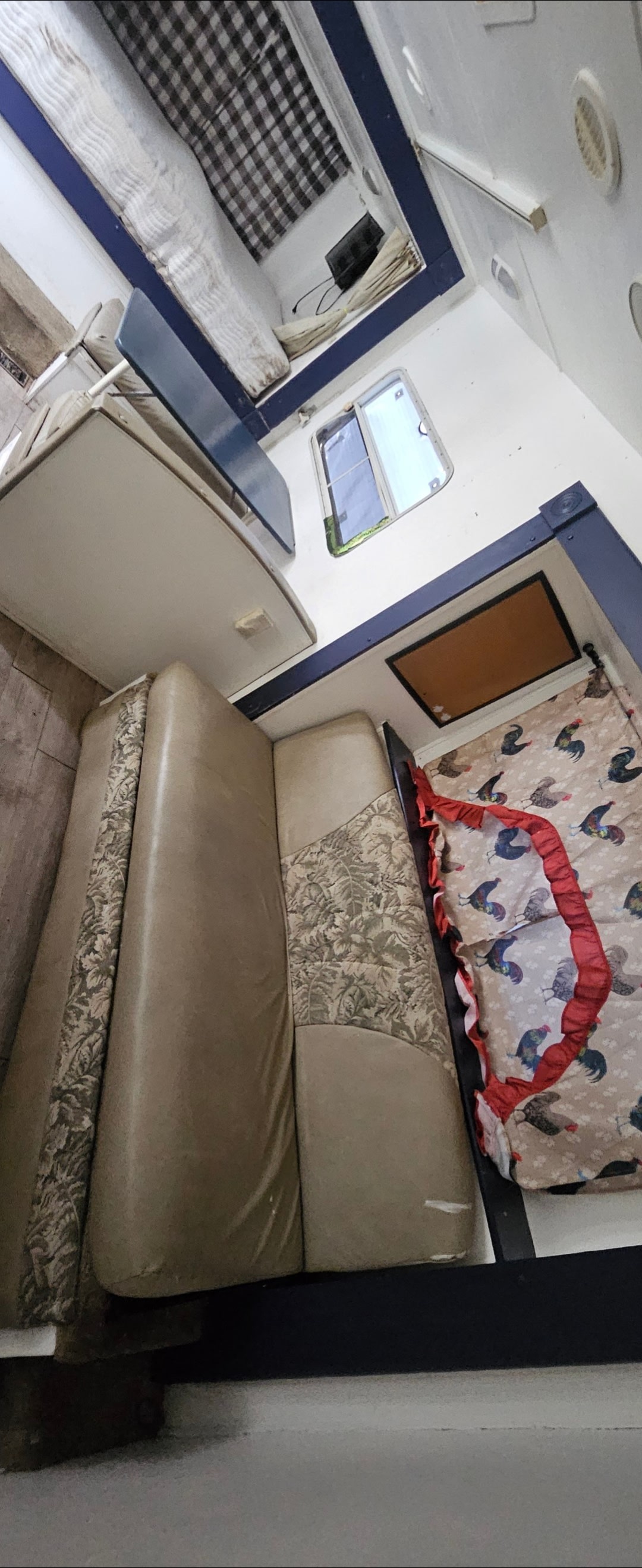 RV rental interior: Comfy dinette, patterned bed, and bunk area visible. Enjoy travel in this cozy accommodation.. Keystone RV Outback 2005