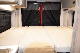 Explore an RV rental's versatile interior: a comfortable three-section bed ready for adventure, with screened rear doors.. Dodge Winnebago 2021