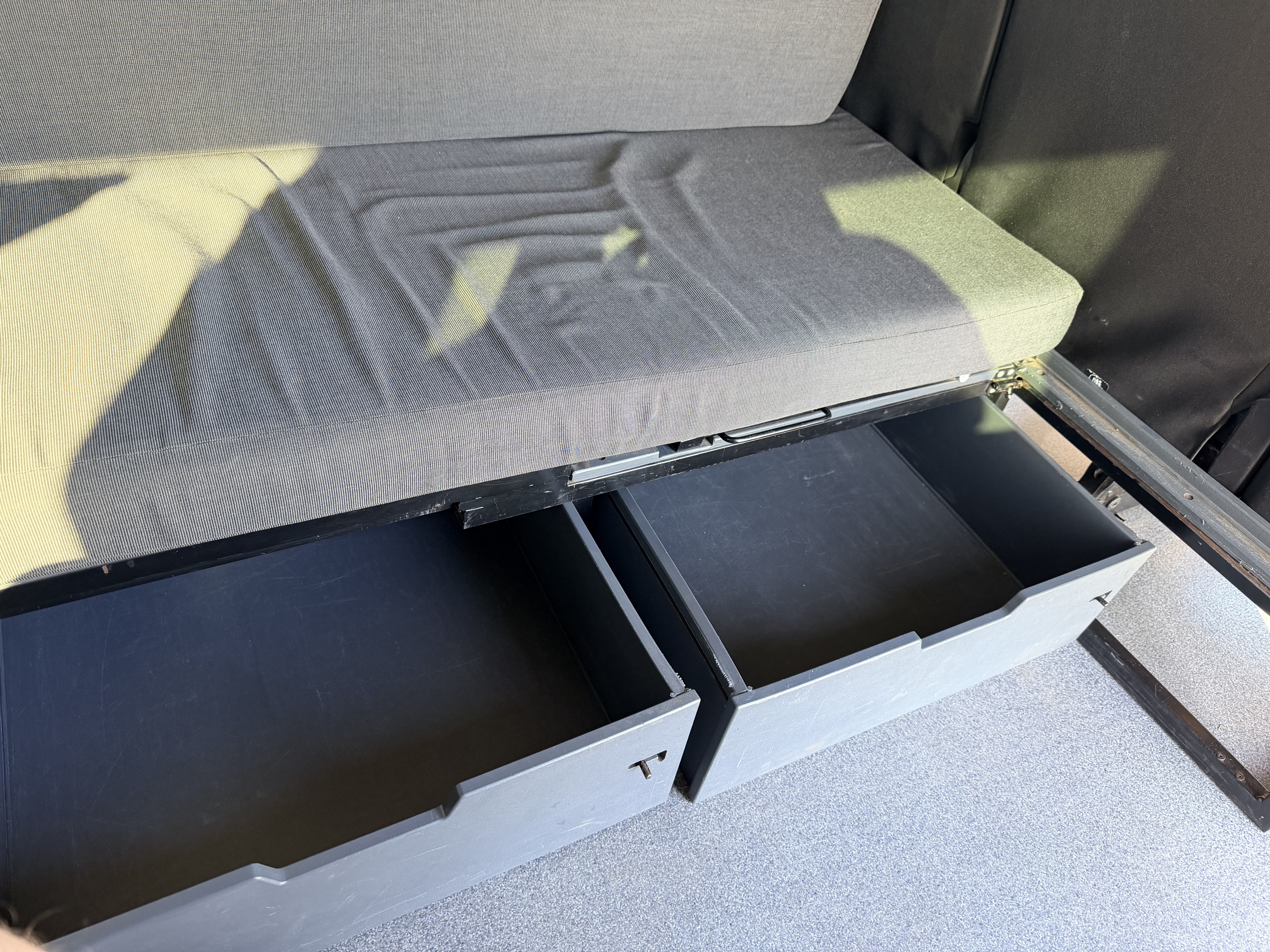 RV rental storage: Two open, dark drawers visible under a gray upholstered seat, offering practical organization for your trip.. Ford Custom Transit 2017