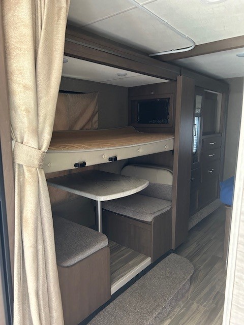 Inside this rv rental, find a compact bunk bed over a dinette, with a TV & storage cabinetry. Ready for your trip!. Thor Freedom Elite 2021