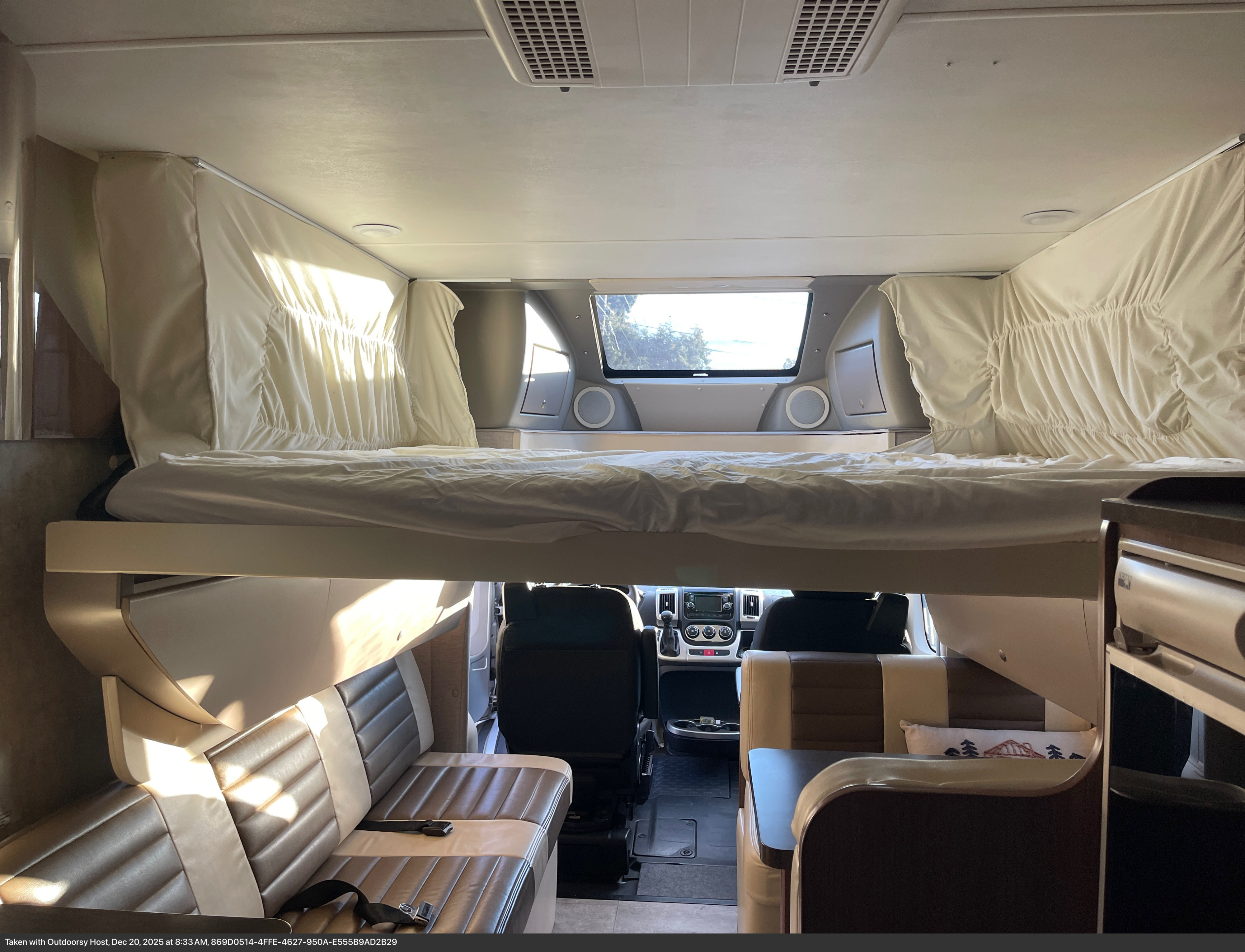 Spacious RV rental interior featuring a cab-over bed, dinette seating, and the driver's cabin for your next adventure.. Winnebago Trend 2015