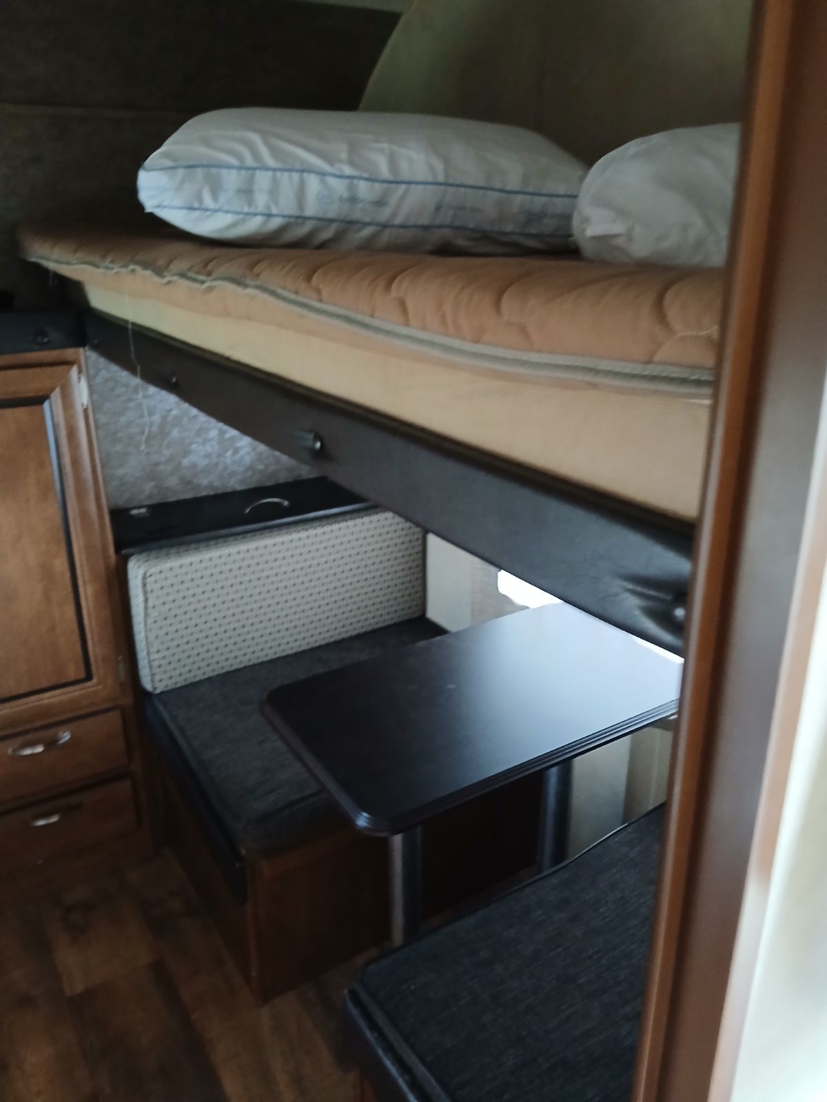 RV rental interior featuring a cozy bunk bed over a dinette with dark table and seating, ideal for compact travel.. Salem 36BHBS 2017
