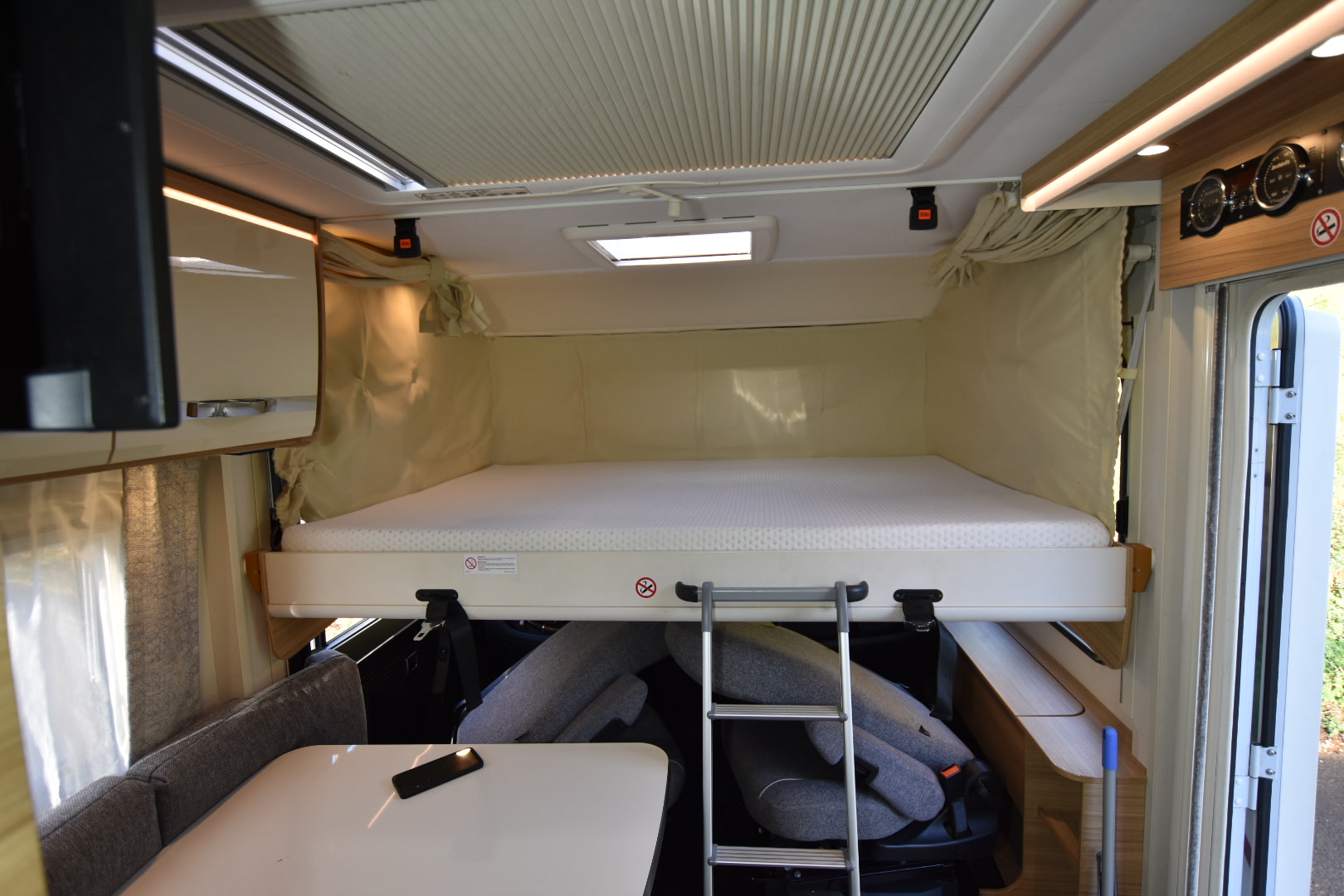 RV rental: Campervan interior with a drop-down bed, ladder, dining area, and overhead controls.. Dethleffs Globebus I 1 2021