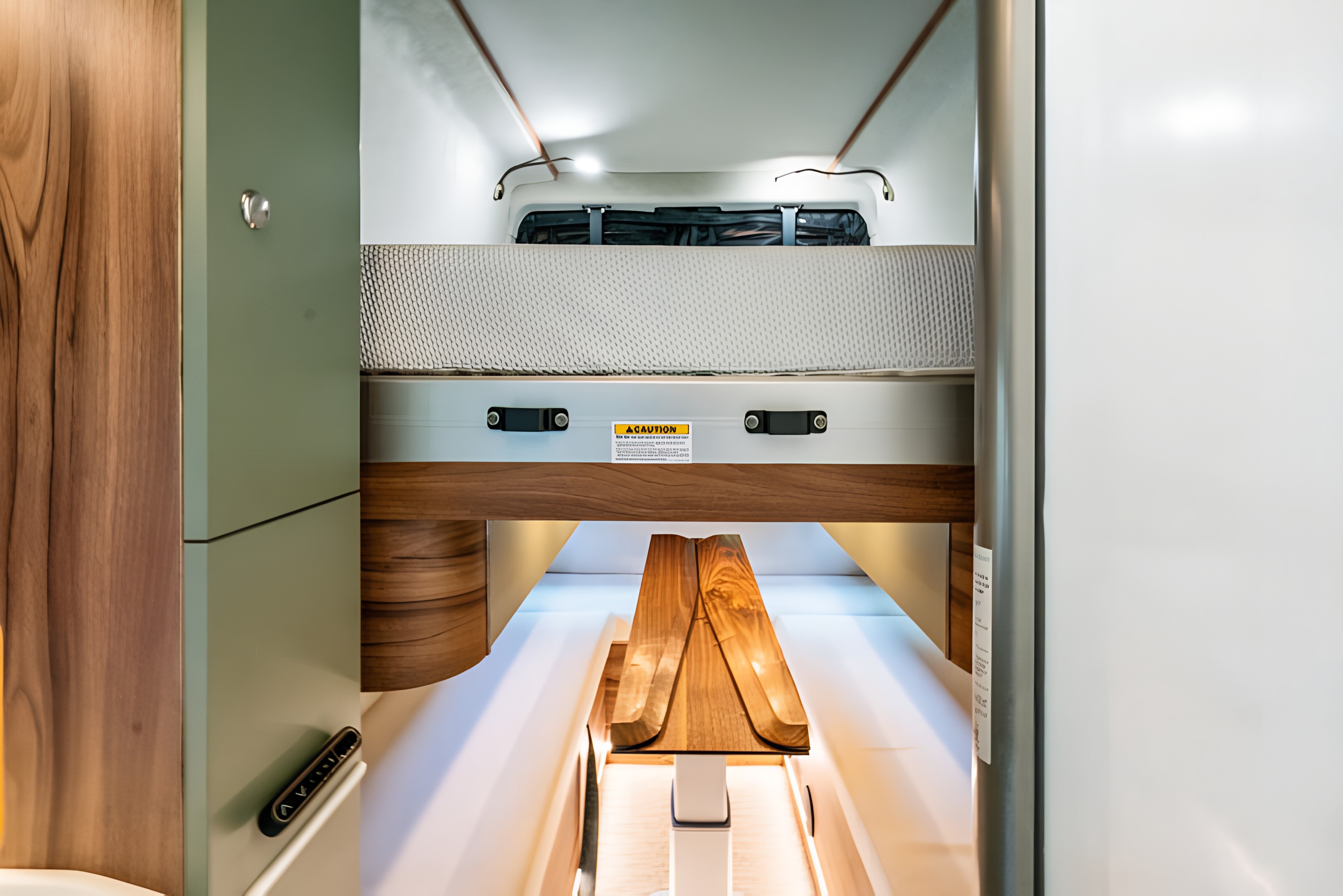 **RV rental** bunk bed suspended above a sleek wooden dining table, a smart and compact interior design for travel.. Noovo Plus LB 2026