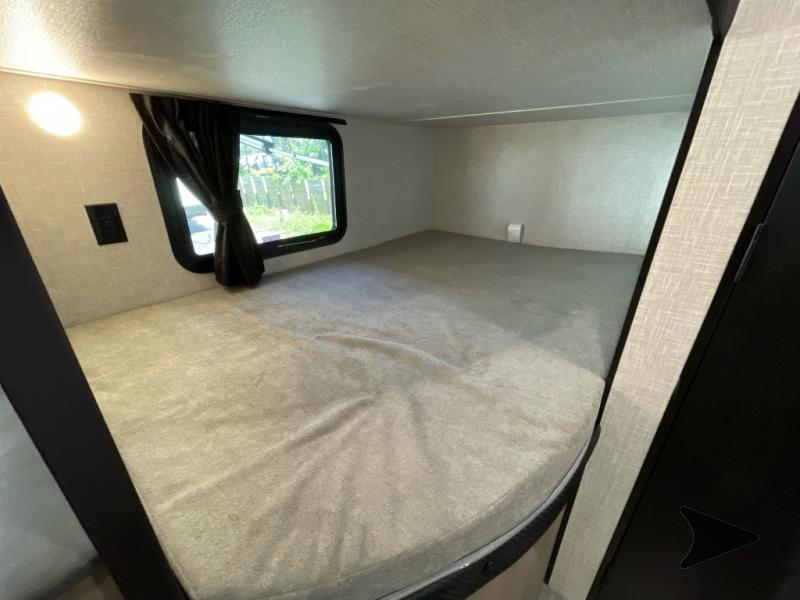 Inside this rv rental, find a cozy bunk bed with light gray mattress, window, light, and outlet. Perfect for travel!. Jayco Jay Flight SLX 2025