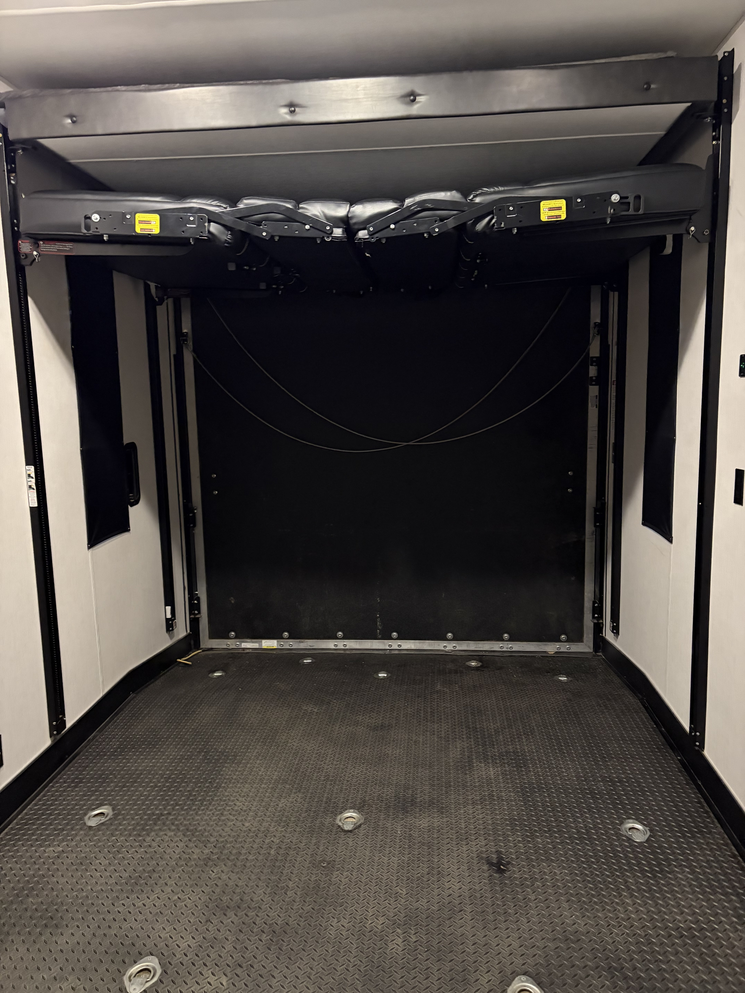 Spacious rv rental toy hauler interior with raised beds, diamond plate floor, and tie-downs, ready for adventure.. Forest River Cherokee Wolf Pack Toy Hauler 2020