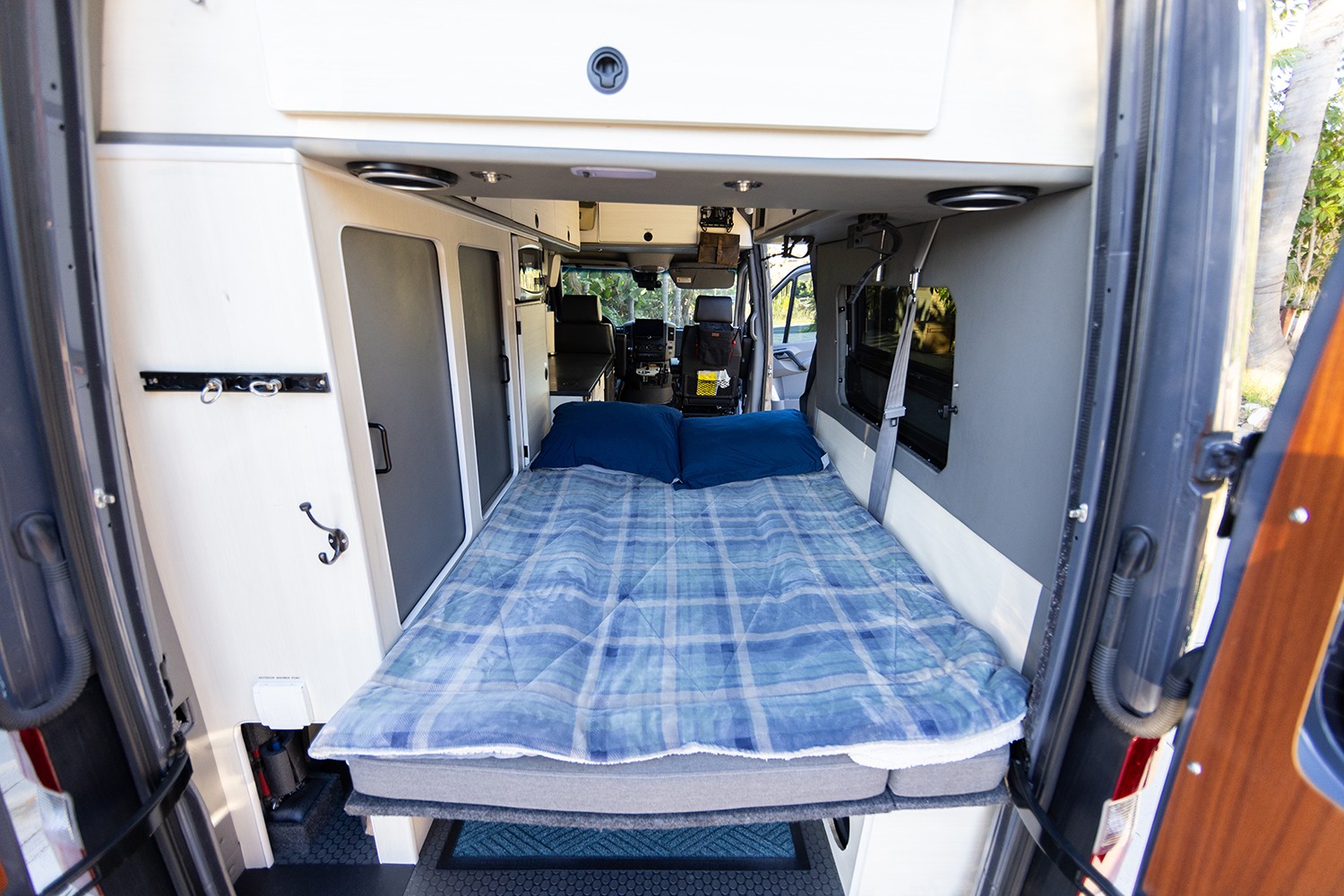 Cozy RV rental interior with a comfy bed, perfect for your next road trip adventure in this camper van.. Sportsmobile 2500 2017