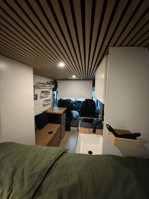 Explore a modern camper van rv rental with a cozy bed, sleek kitchen, and distinctive slatted ceiling design.. Dodge RAM Promaster 2500 High Roof 2022