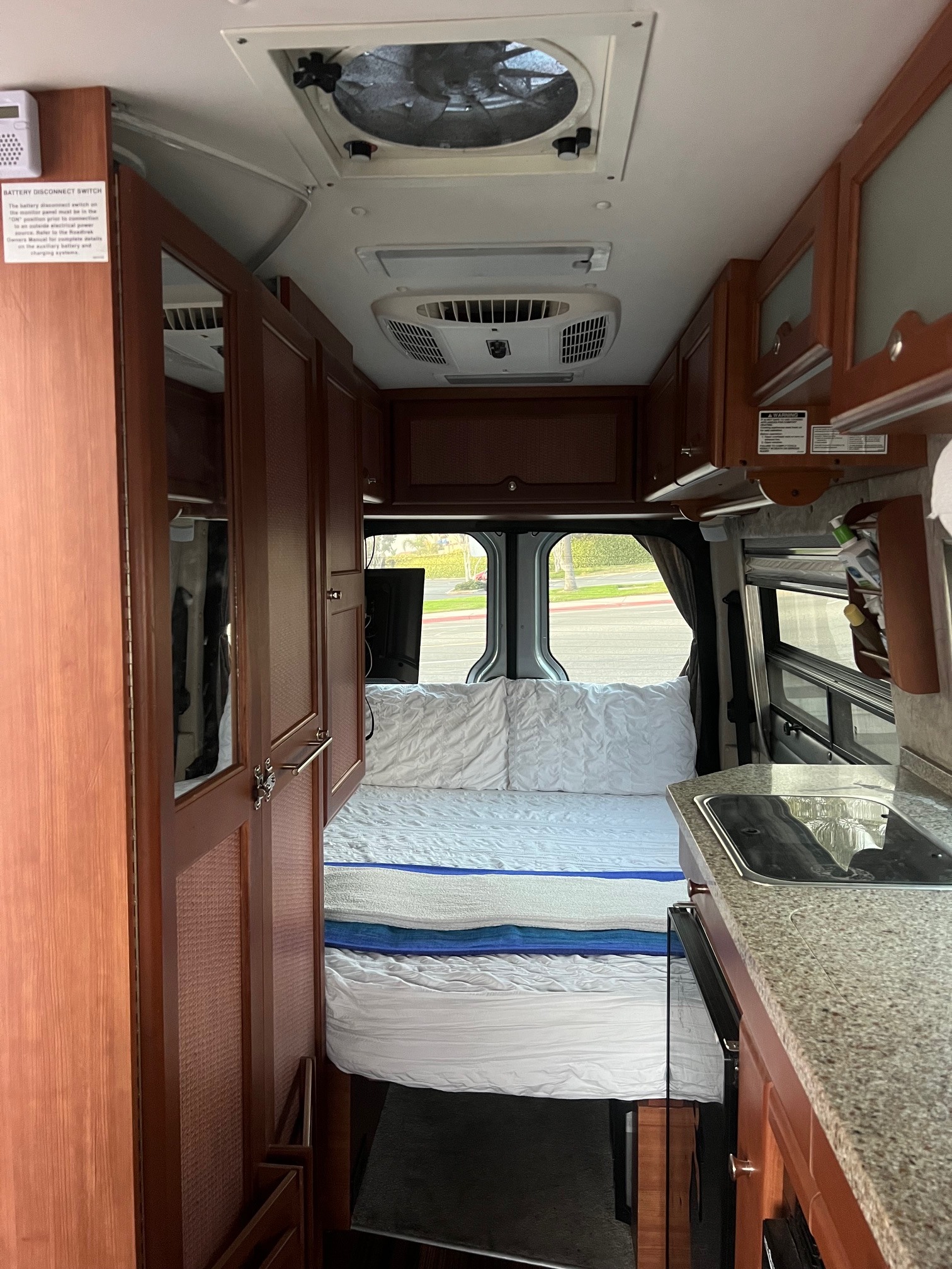 Cozy interior of an RV rental featuring a comfortable bed, functional kitchenette, and ample storage for travel adventures.. Roadtrek Roadtrek Class B 2008