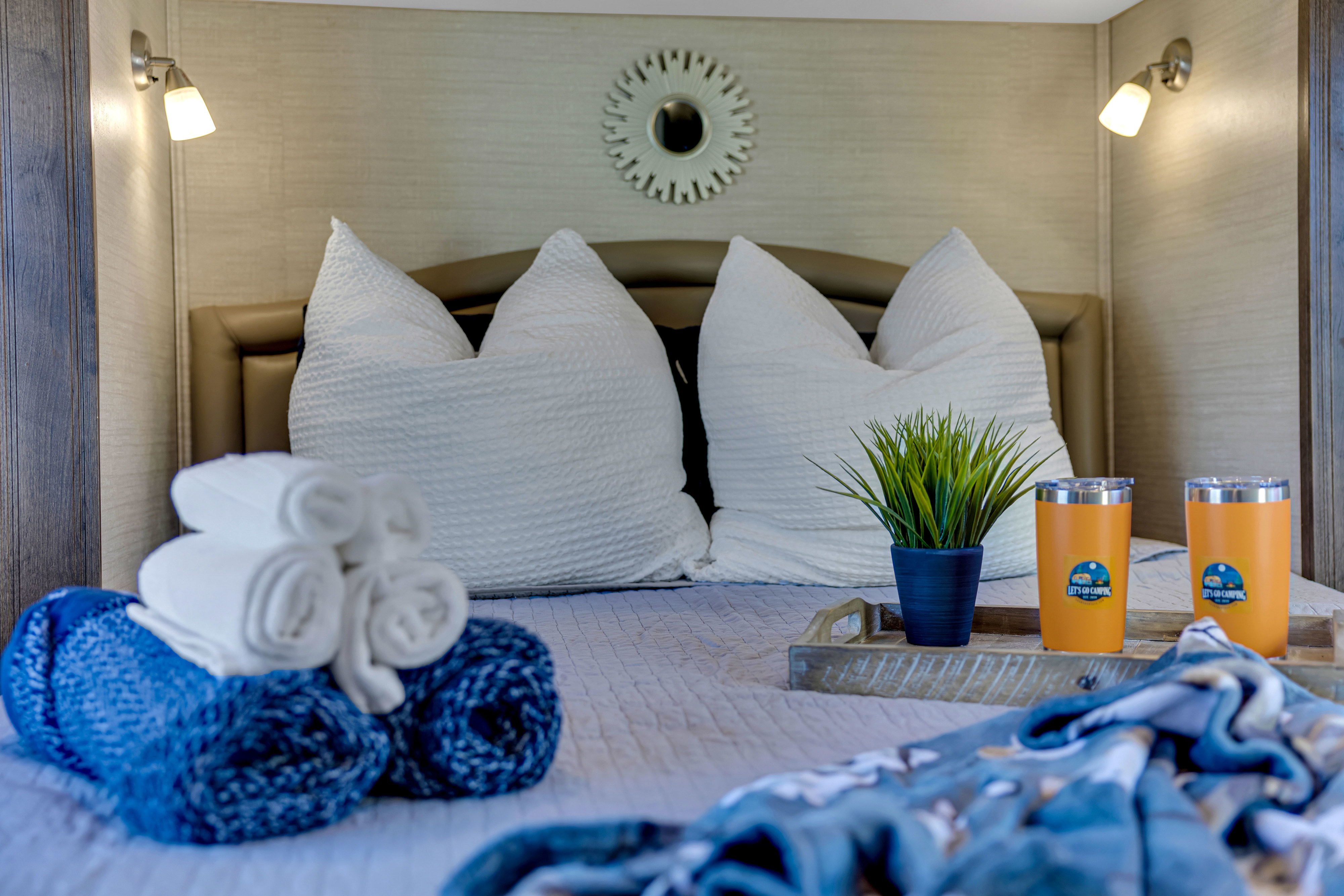 Comfortable RV rental bedroom featuring soft bedding, camping tumblers, and towels, ready for your next adventure.. Jayco Greyhawk 2018